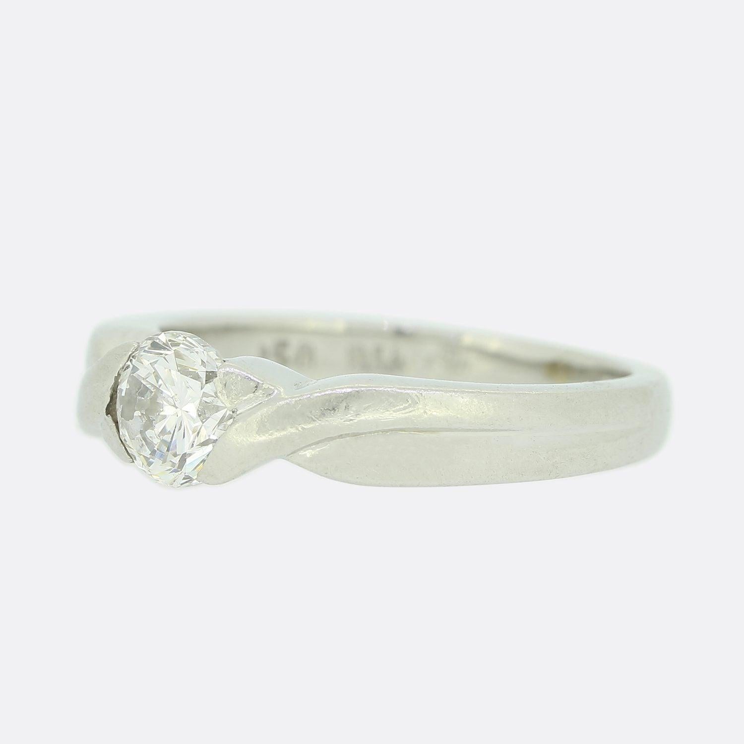 This is a beautiful diamond solitaire engagement ring. The ring has been masterfully handcrafted and features a stunning 0.50 carat brilliant cut diamond that sits in a rubover setting. The band has a cross over style setting and has been made in