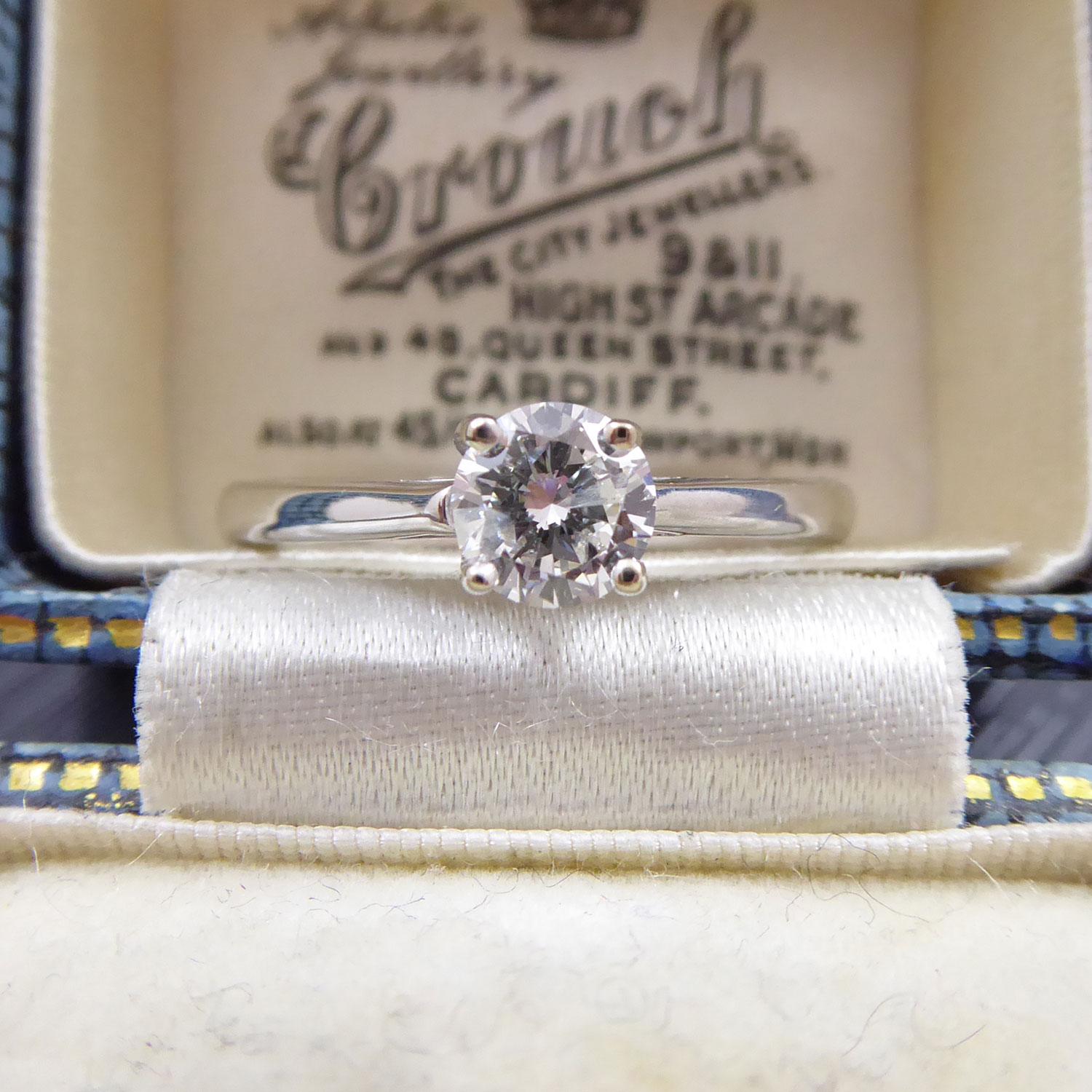 A diamond solitaire ring set with a round brilliant cut diamond, 0.50ct (stated on inside of band) with assessed colour of G/H and assessed clarity of I1.  The diamond sits in four white claws to a white plain polished band.  The band is hallmarked