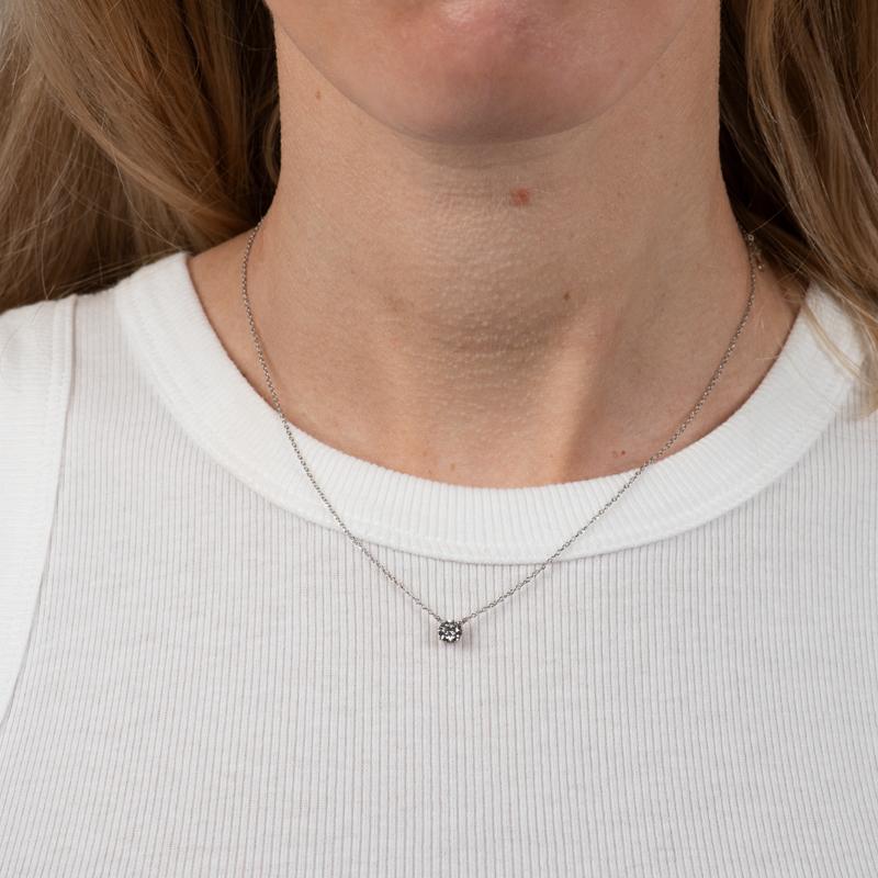Ce collier comporte un diamant naturel rond de 0,50 carat, H-I SI2,  serti dans une monture en forme de panier sur une chaîne réglable de 18