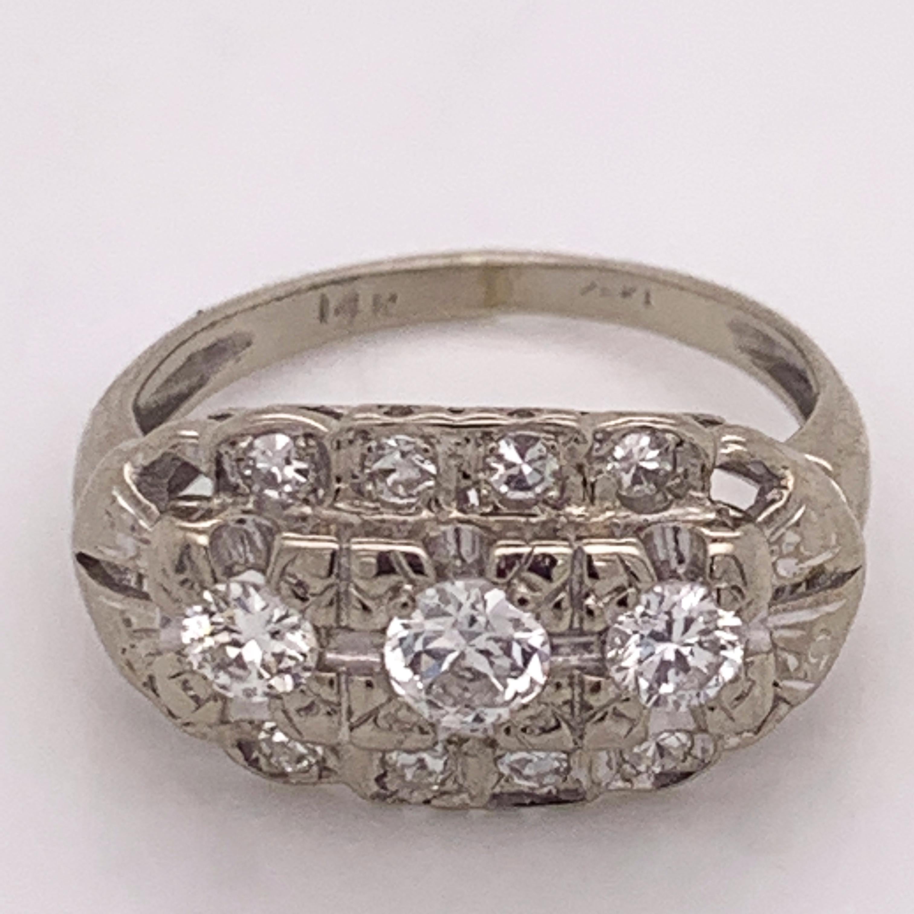 This Art Deco Three-Stone Diamond Engagement Ring set in 14 Karat white gold dates back to the 1920's and has such a beautiful and notable design. Round brilliant cut diamonds were first marketed in 1919 and are what sets this stunning ring apart