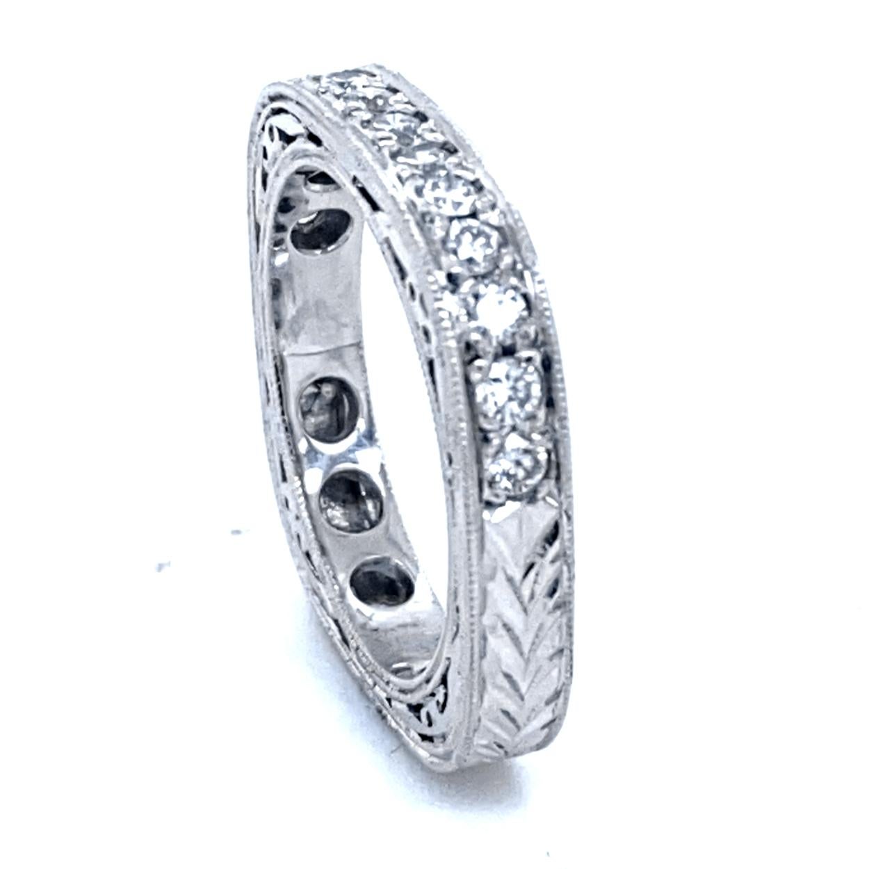 This Antique design Wedding Ring is made in Platinum with 13 pieces of 2.1 mm Round diamonds pave set in the middle with total weight of of 0.50 Ct.  The ring is square shaped with Hand Engraving on the shank and accented with milgained edges &