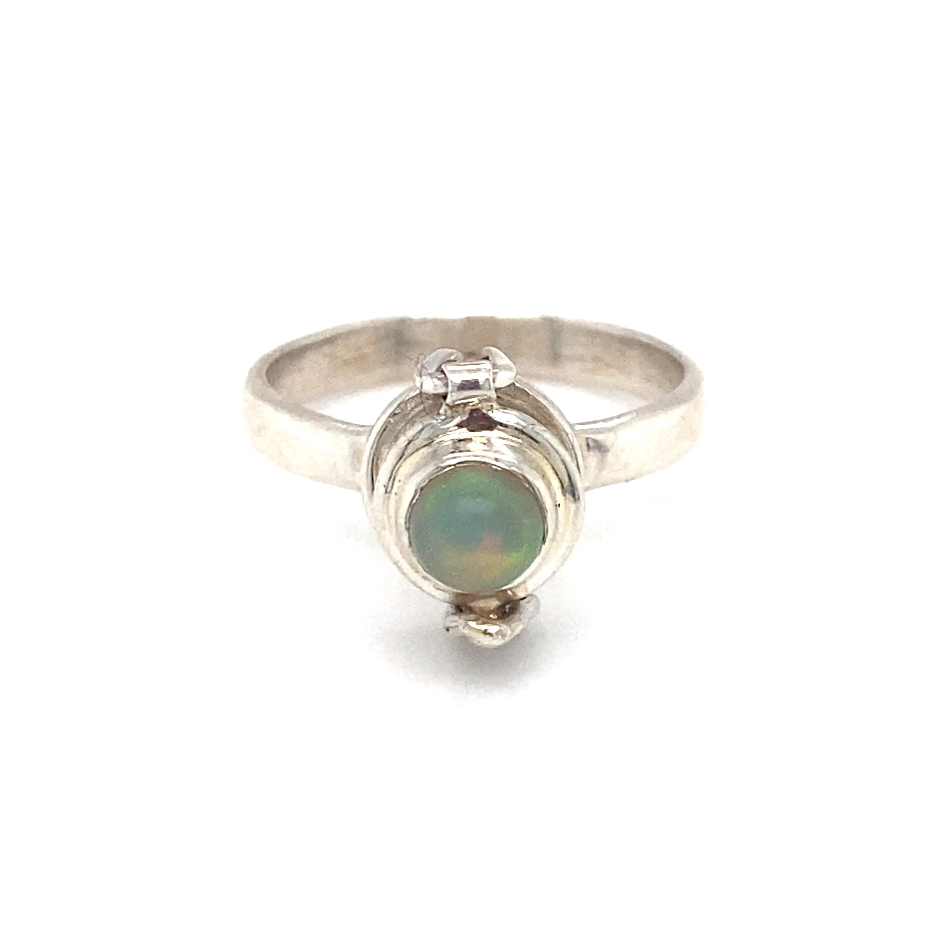 
Item Details: This poison ring has a round Ethiopian jelly opal set in sterling silver.

Circa: 21st Century
Metal Type: Sterling Silver
Weight: 2.9g
Size: US 6.5, resizable
