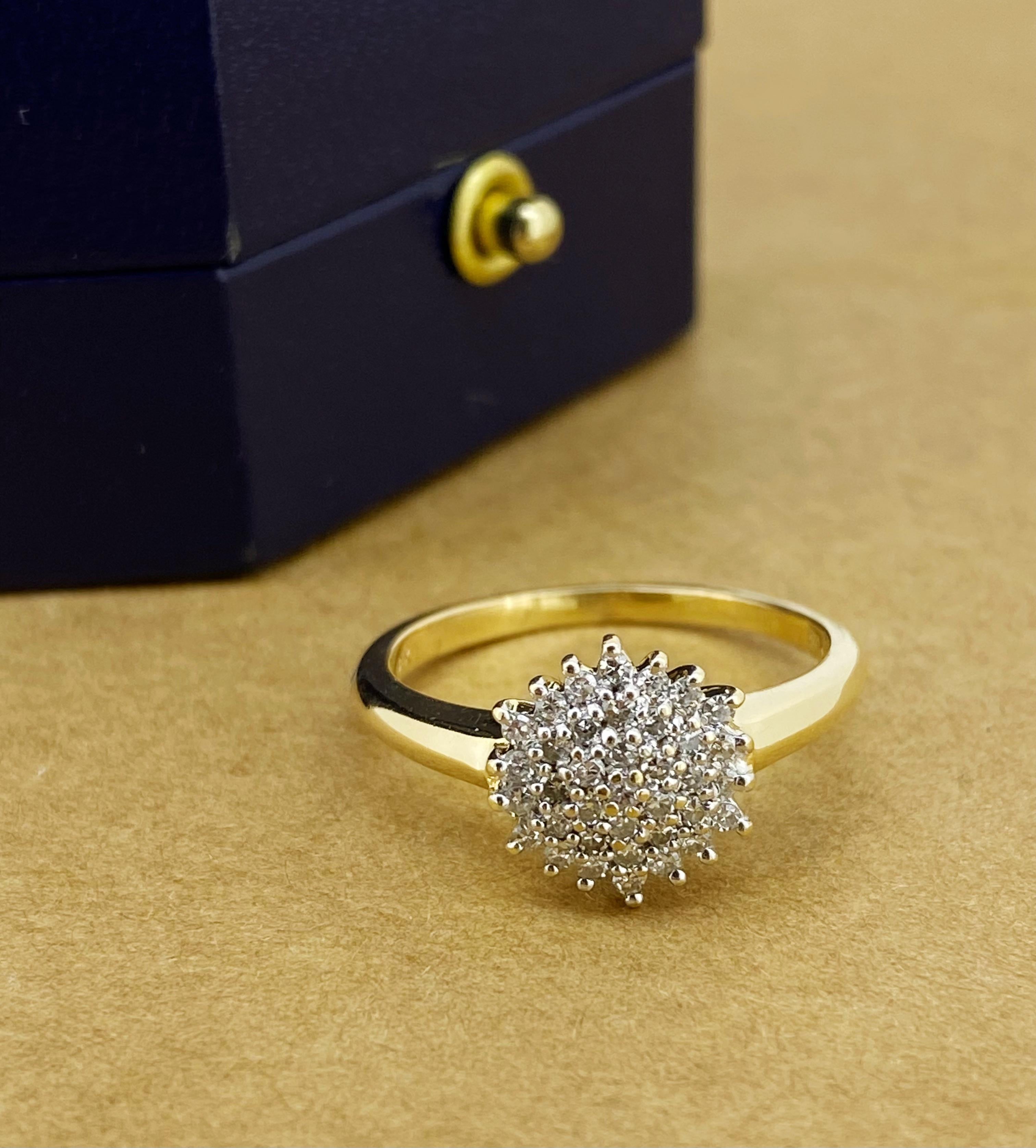 Cette bague à fleurs et diamants 
est réalisé en or jaune 18 carats 
avec une attention particulière aux détails :

Conçu comme une tête de fleur, 
centré d'une grappe de diamants ronds de taille brillant 
d'une couleur G/H et d'une brillance