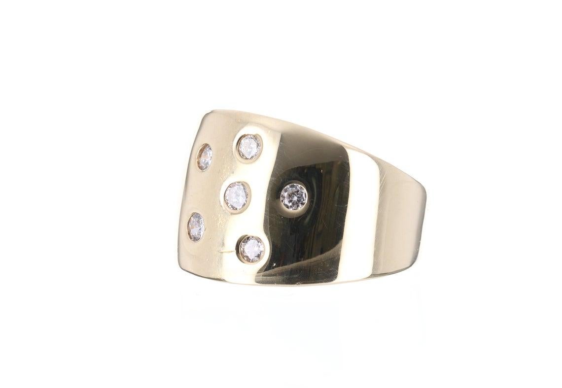 Displayed is a wide diamond gold band in 14K yellow gold. Six, brilliant cut diamonds are bezel set in the center and are enhanced by smooth yellow gold. The diamonds weigh a total of 0.50pts. The widest part of the ring measures 14.5mm wide and
