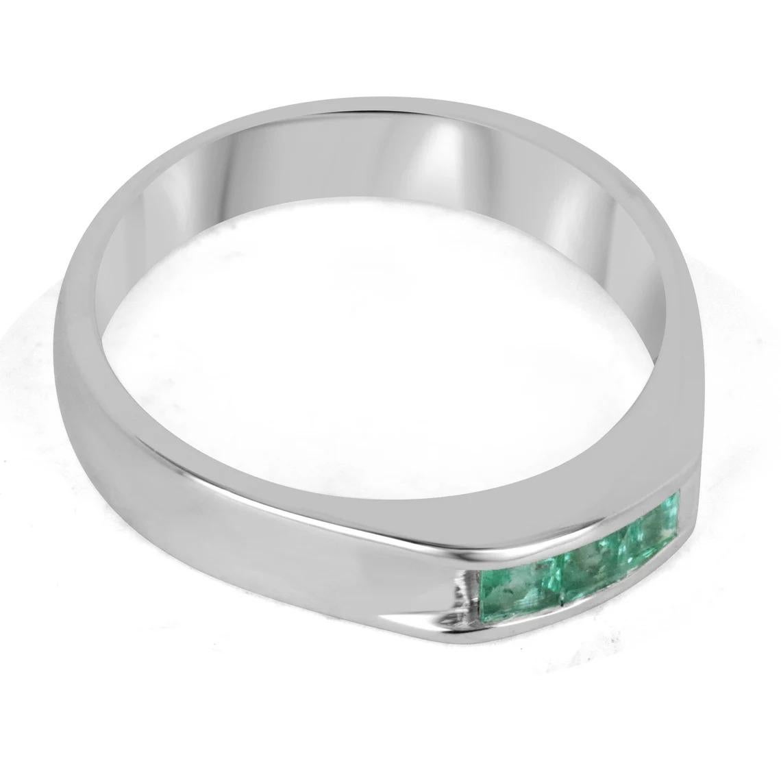 A dapper natural emerald men's ring that features three princess cut emeralds in the very center bezel set east to west. The gemstones showcase a lovely medium green color with excellent-very good clarity and luster. Crafted in a sterling silver