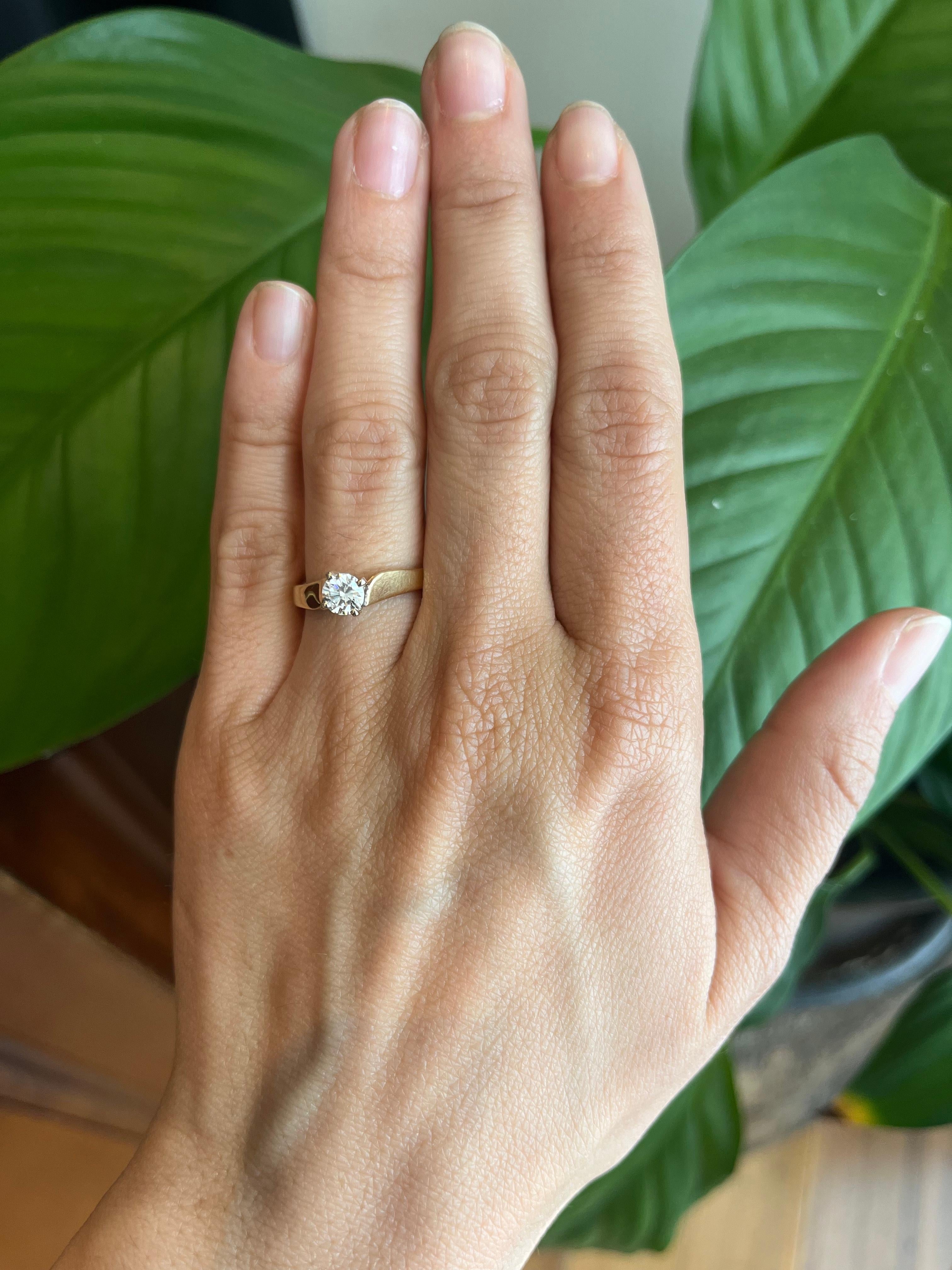 Bague de fiançailles solitaire intemporelle ornée d'un diamant rond naturel de 0,51ct dans une monture en or jaune 14 carats avec une tête en or blanc (griffes) pour plus d'éclat et de brillance. La bande légèrement incurvée se divise à l'endroit où