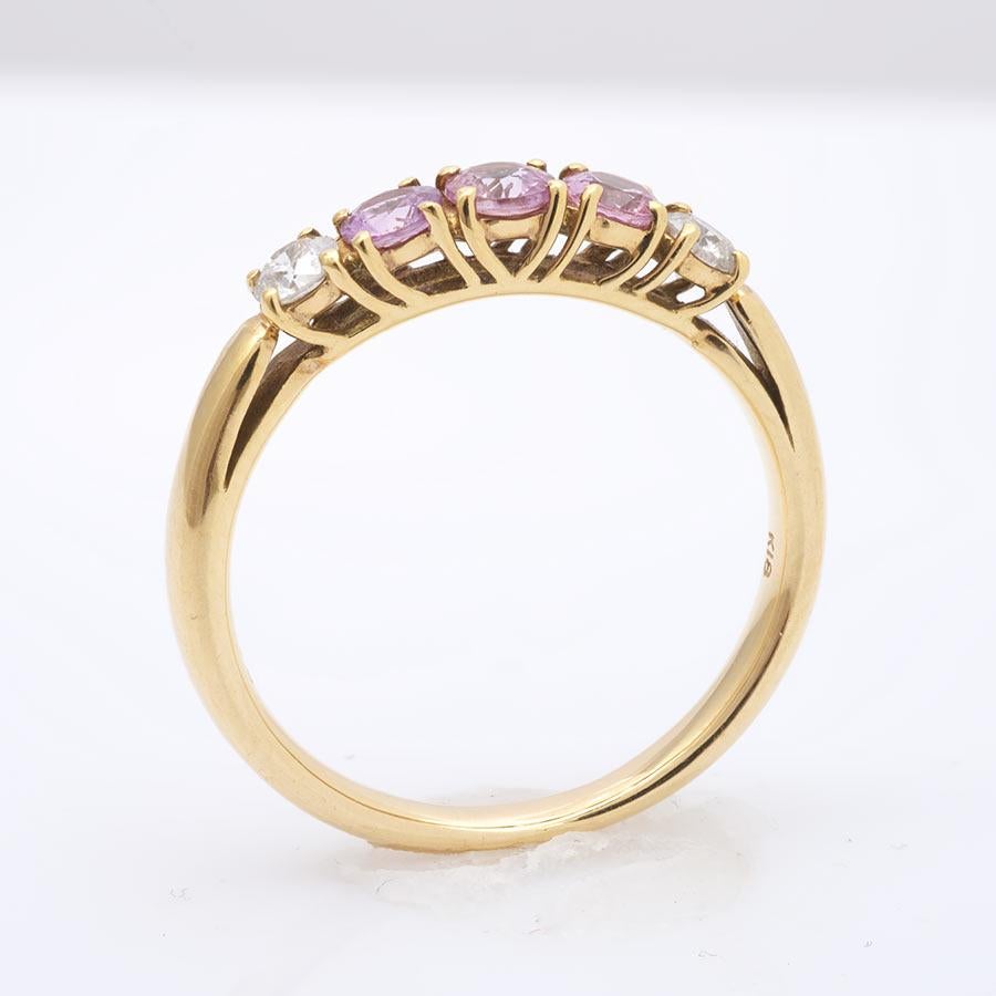 This timeless band set with three centrally located pink sapphires and diamonds at its side has a nice pastel color that reflects off each other beautifully. Set in 18K yellow gold prongs, each stone is secure perfect for everyday use.

Ring