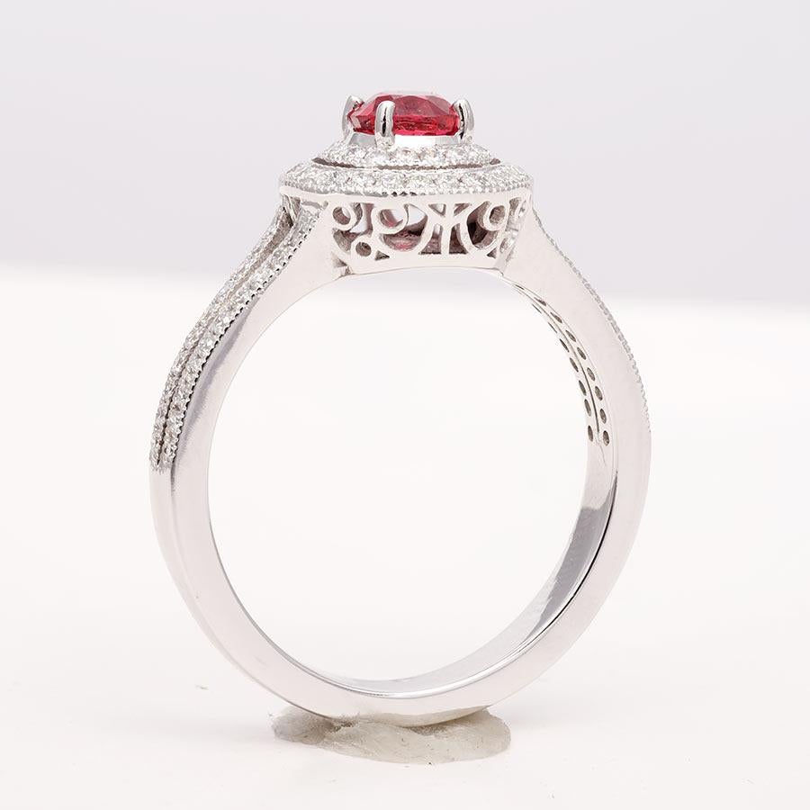 At 0.52 carats, this round brilliant spinel has an unmatched red color. Set on a wreath of diamonds the ring has an illusion of a both a bigger stone plus they look beautiful and sparkly. The diamonds that run onto the band of the ring lays all the