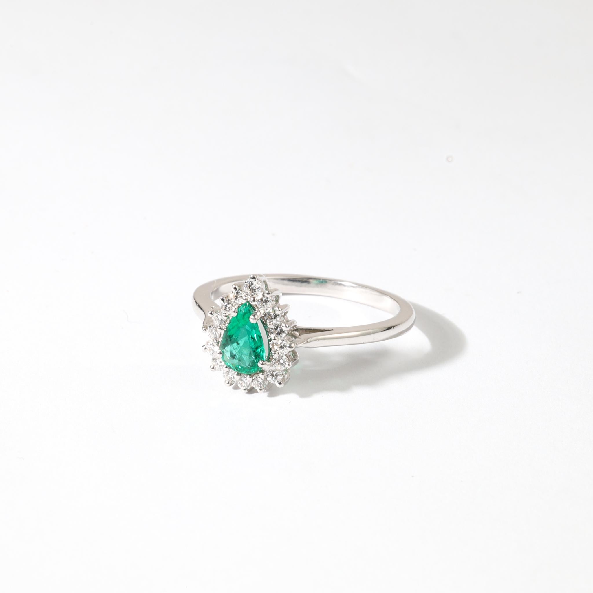 Description du produit :
Évoquant un sens du glamour intemporel et de la sophistication romantique, cette bague de fiançailles halo en émeraude taillée en poire est une célébration exquise de l'amour et de l'art. Au centre se trouve une vibrante