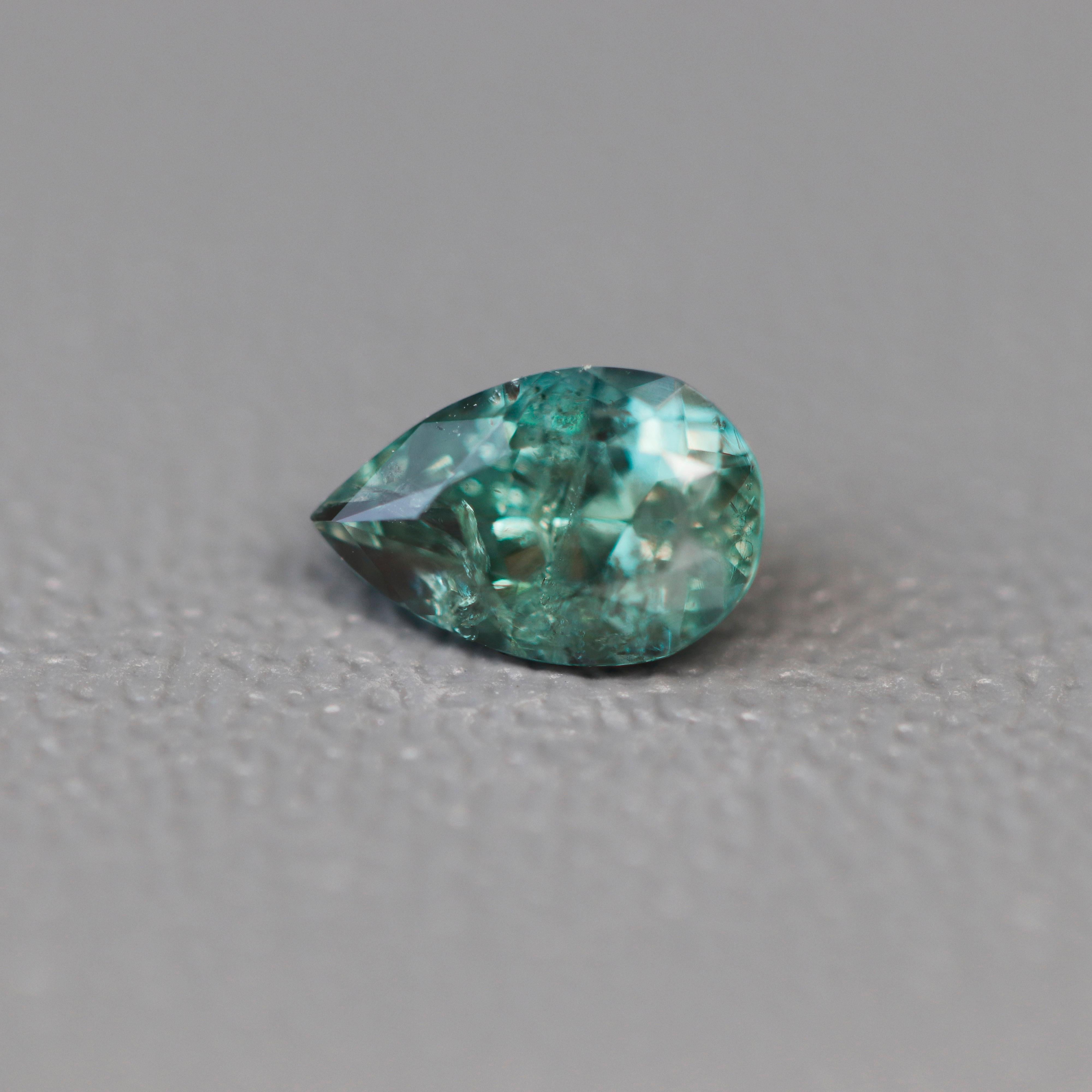 Questo squisito pezzo di meraviglia della natura è un'affascinante alessandrite russa del peso di 0,53 carati. 

L'alessandrite russa naturale è rinomata per le sue notevoli proprietà di cambiare colore, passando da una lussureggiante tonalità