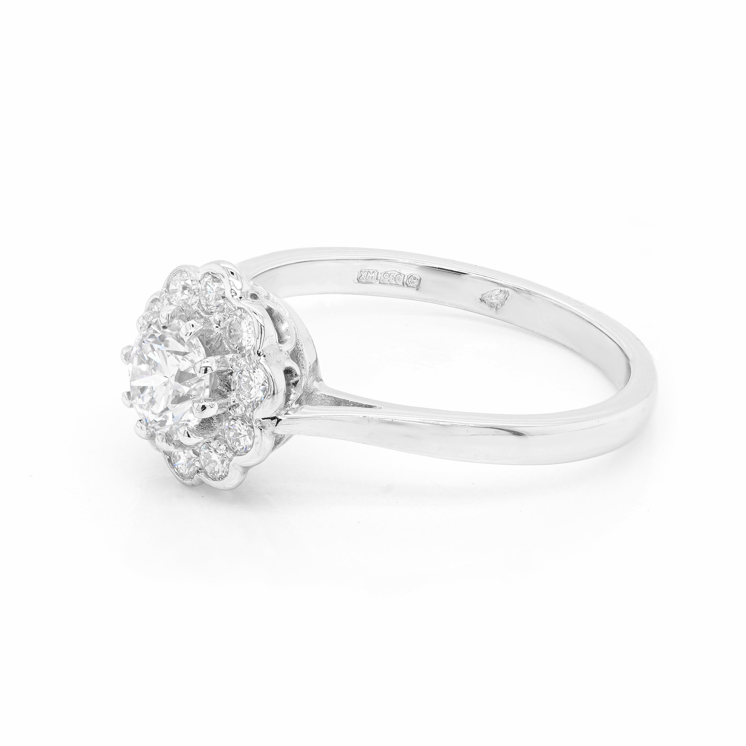 This lovely coronet cluster ring is beautifully centred with a 0.53ct round brilliant cut diamond, certified F in colour and VS2 in clarity, mounted in a ten claw, open back setting. The beautiful stone is surrounded by 10 smaller round brilliant