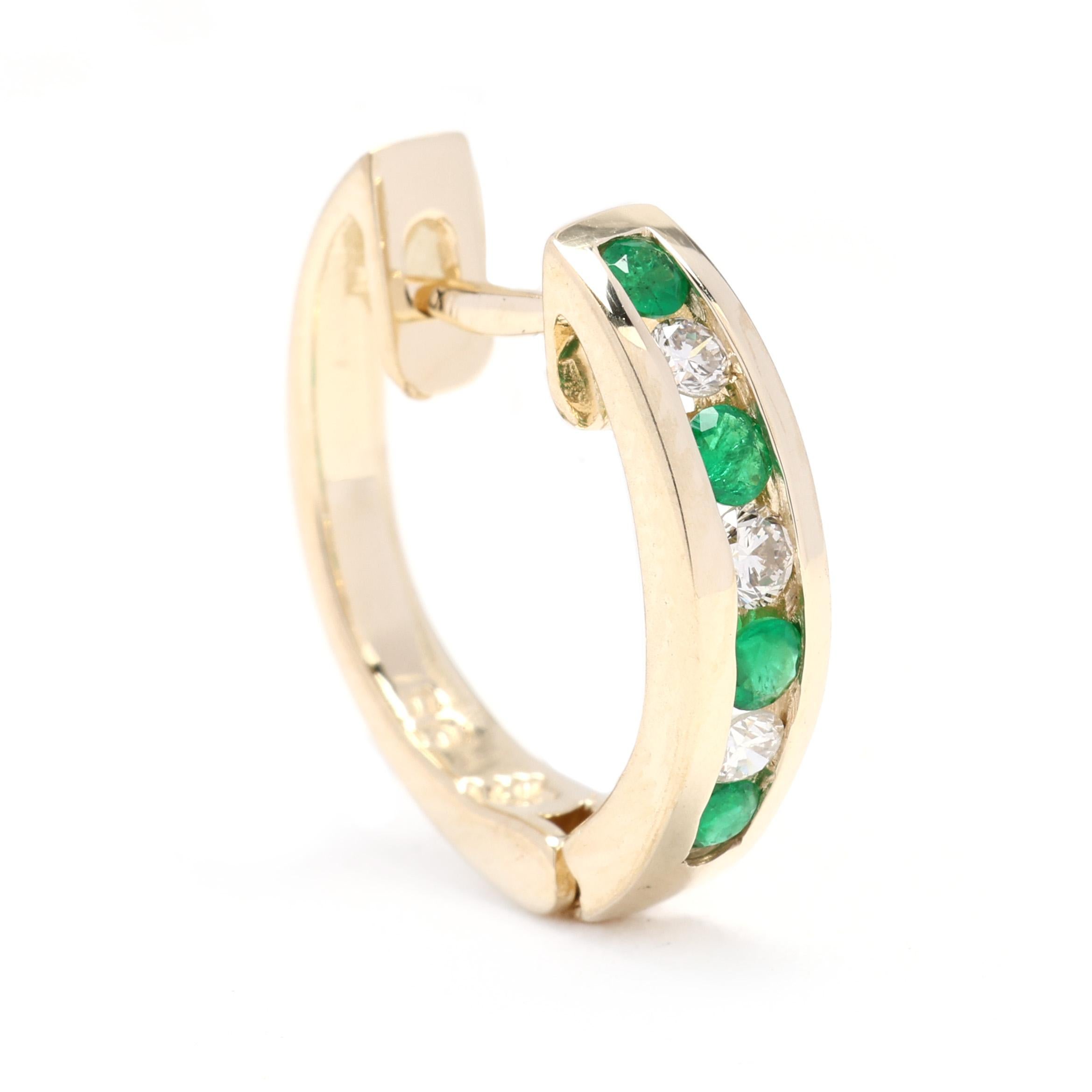 These stunning 14k yellow gold huggie hoops are adorned with a total carat weight of 0.53 diamonds and vibrant emeralds. The diamonds and emeralds are prong-set along the front of the hoops, creating a beautiful contrast between the sparkling