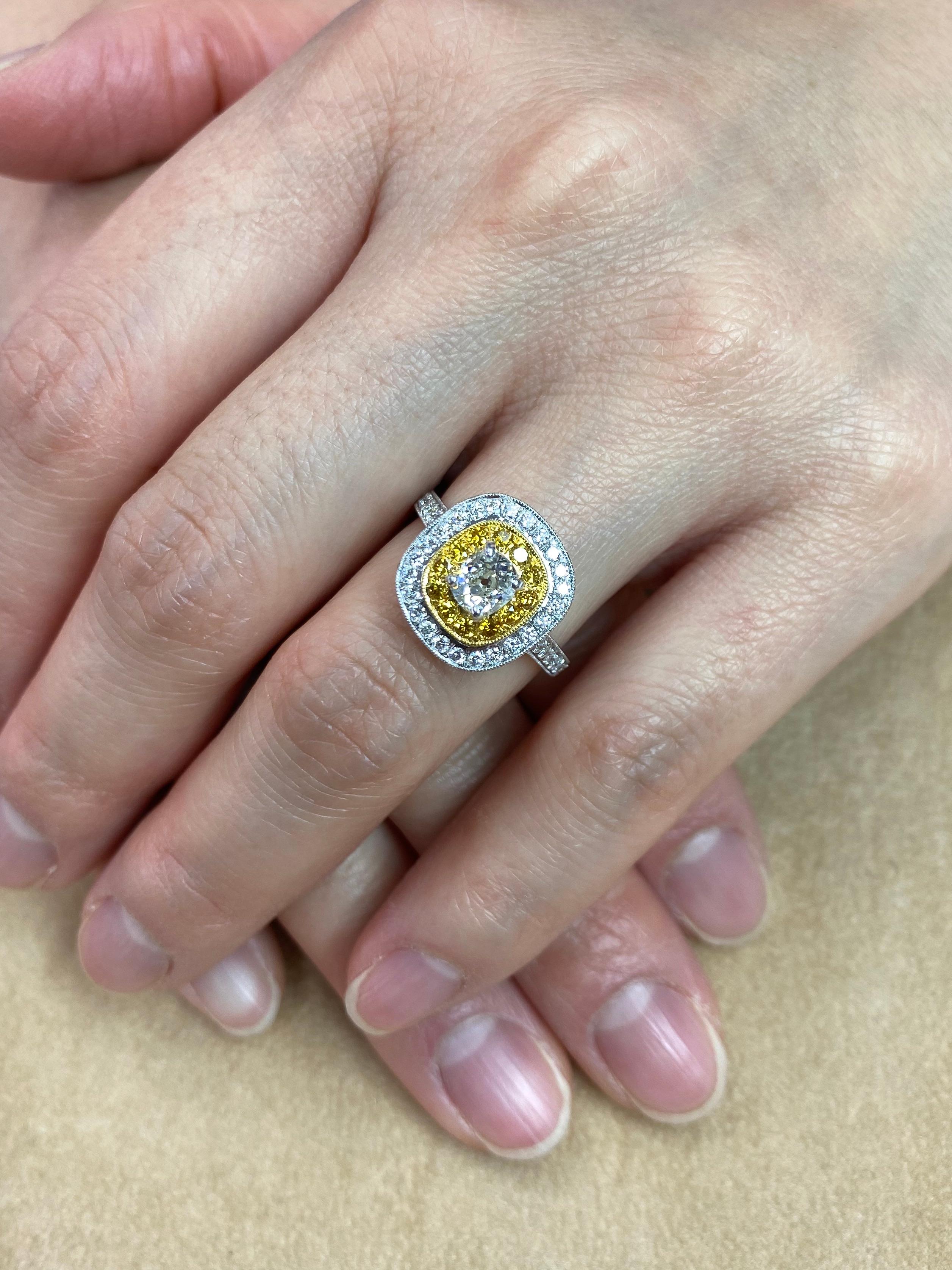 Here is a ring uniquely put together using a antique old mine cut diamond and colorful fancy vivid yellow diamonds. The ring double halo set in 18k white gold. The center antique old mine cut white diamond is 0.54 Cts. The first halo of fancy vivid