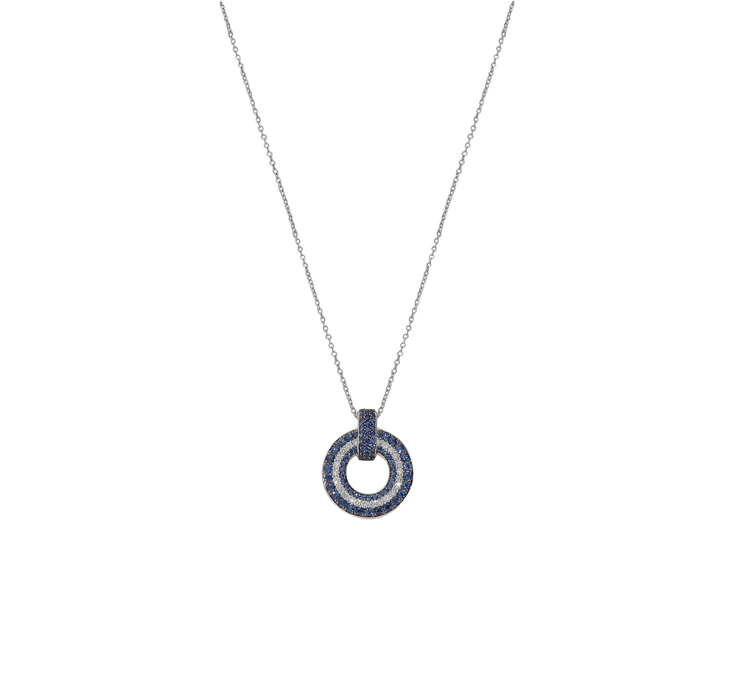 Modern circle pendant necklace in 18kt white gold for 8,00 grams, white round brilliant diamonds color G clarity SI for 0,54 carat and blue round brilliant sapphires for 1,78 carats.
The diameter of the circle is 2,10 centimeters and the length is