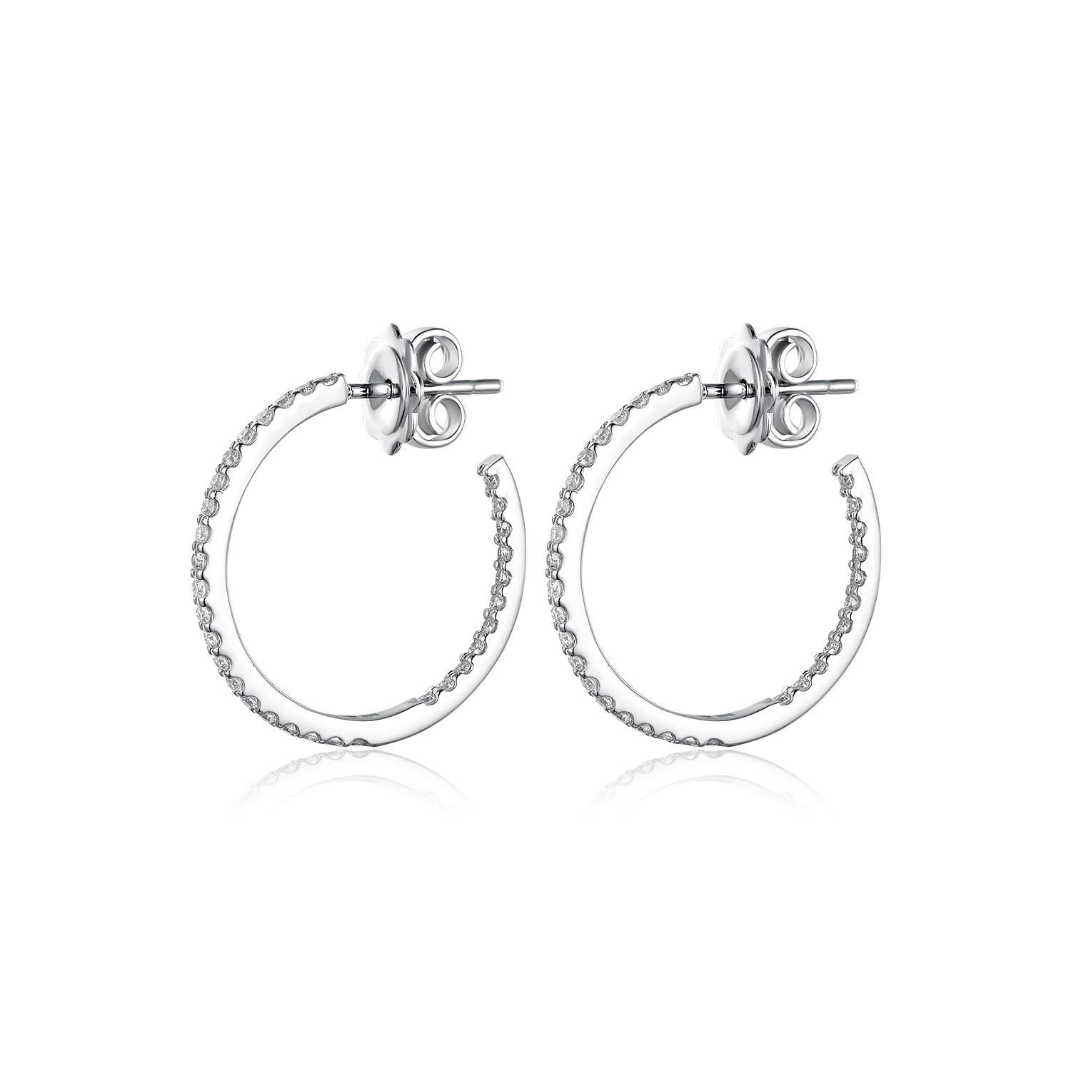 These classic hoop earrings, finely crafted from 14 karat white gold, are a quintessential addition to any jewelry collection. They feature a full circle of radiant diamonds, totaling 0.55 carats, that encrust the surface with a dazzling display of