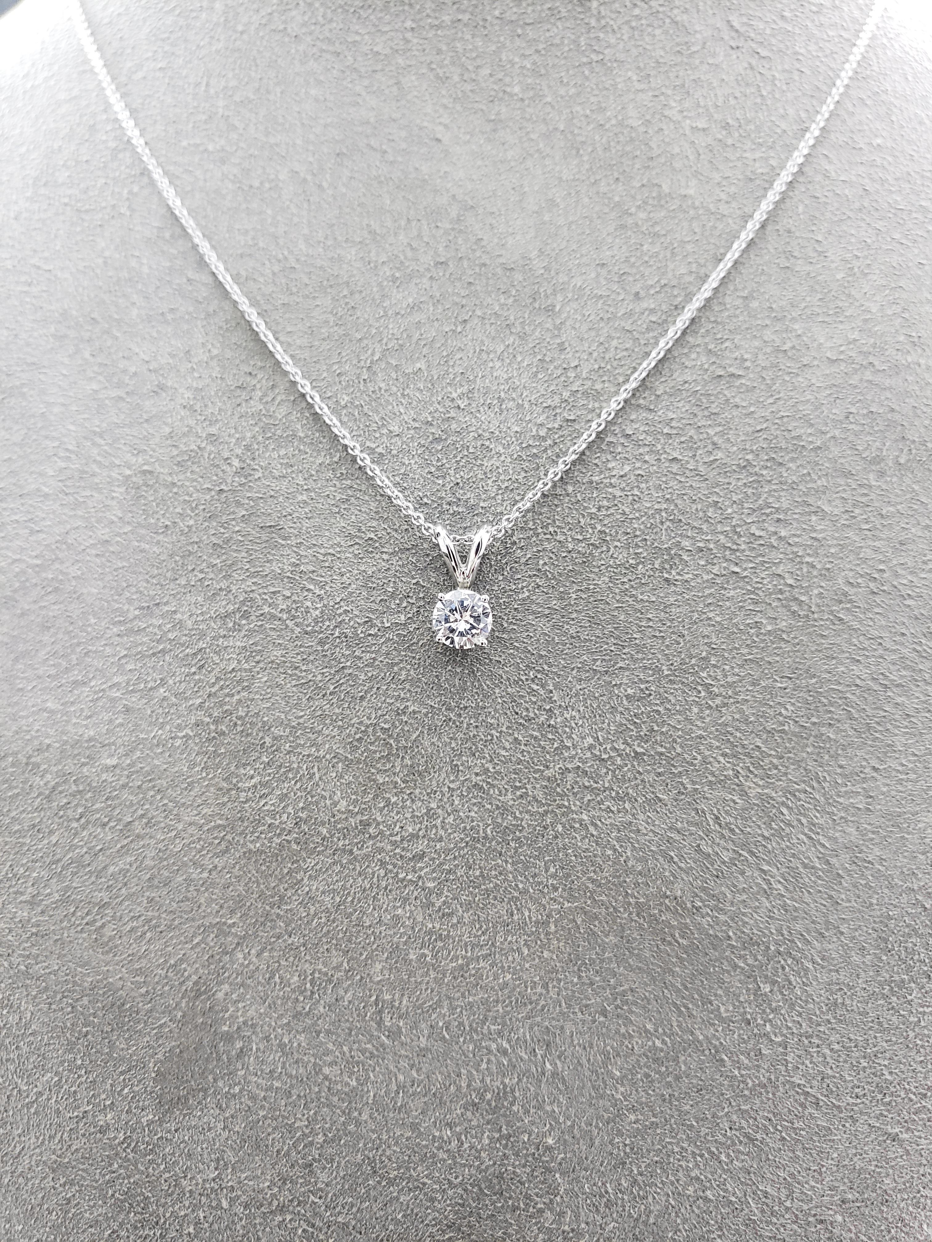 A simple and timeless solitaire pendant necklace showcasing a round brilliant diamond in a 4 prong white gold basket setting. Suspended on a rabbit ear bail attached to a 16 inch white gold chain. A magnificent piece.

Style available in different