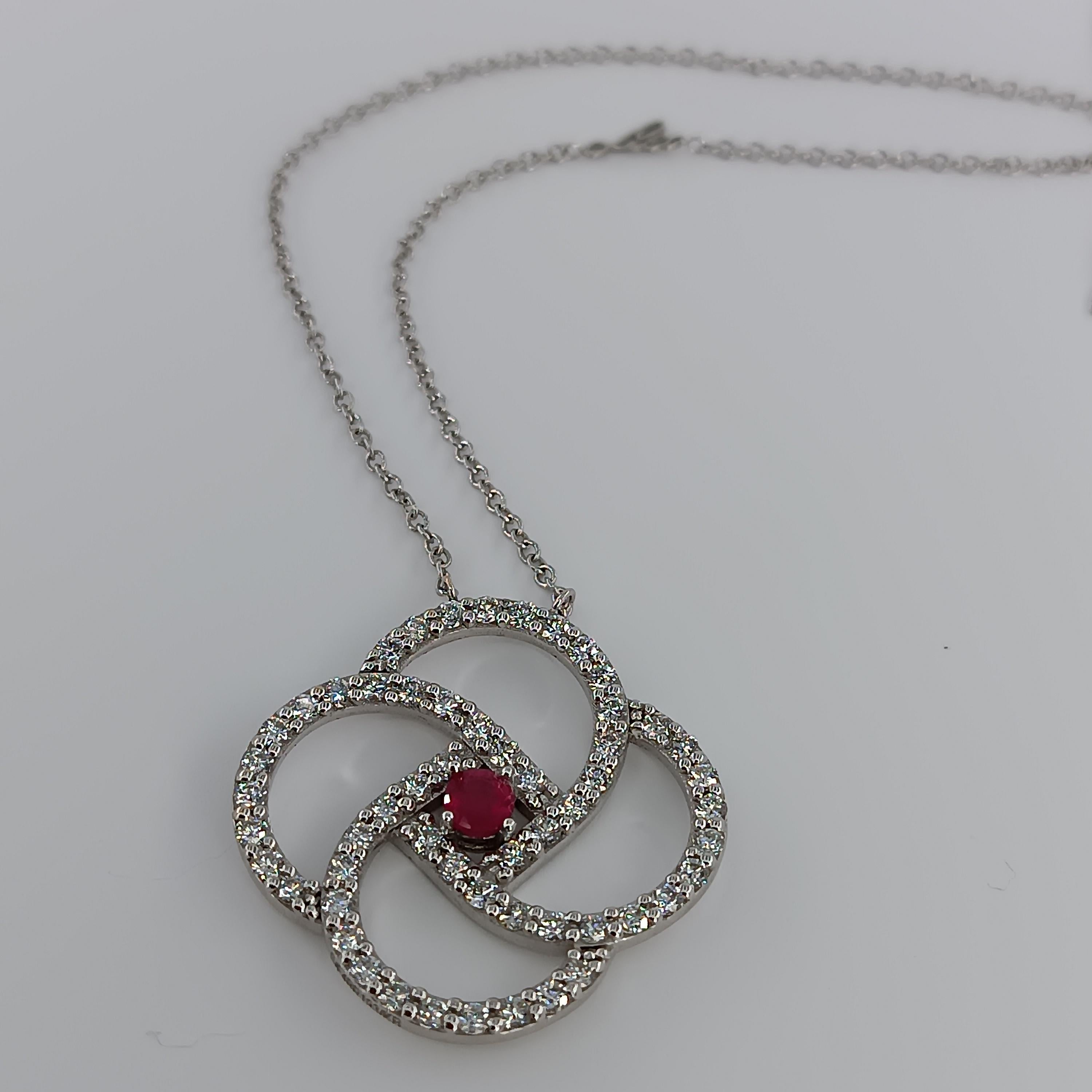 This beautiful pendant made of 18 carat White gold for 9.42 grams boasts a central ruby of 0.55 carat and 56 VS G color diamonds for a total of 1.68 carats. 
any item of our jewelry collection has a dedicated identification number lasered on the