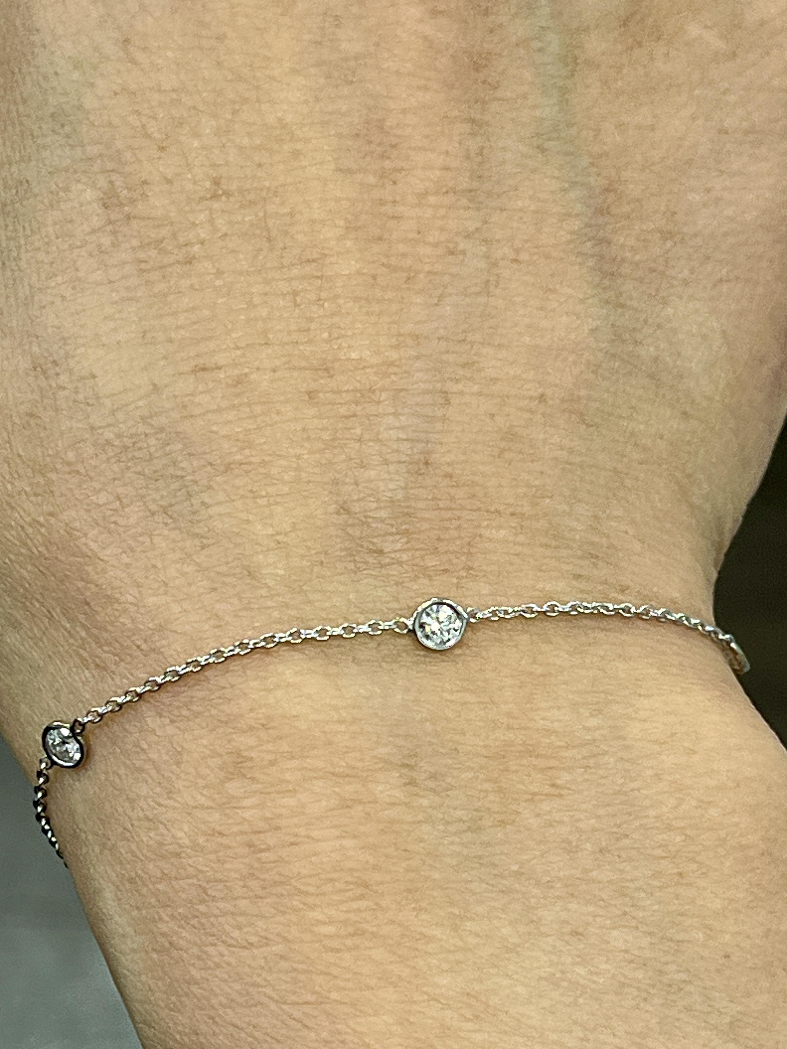 Esta elegante pulsera de diamantes por yardas presenta un delicado diseño con diez diamantes redondos engastados en oro blanco de 14k. El diamante, de 0,55 quilates, es de color G y claridad VS2. La pulsera mide 7 pulgadas de largo y se puede