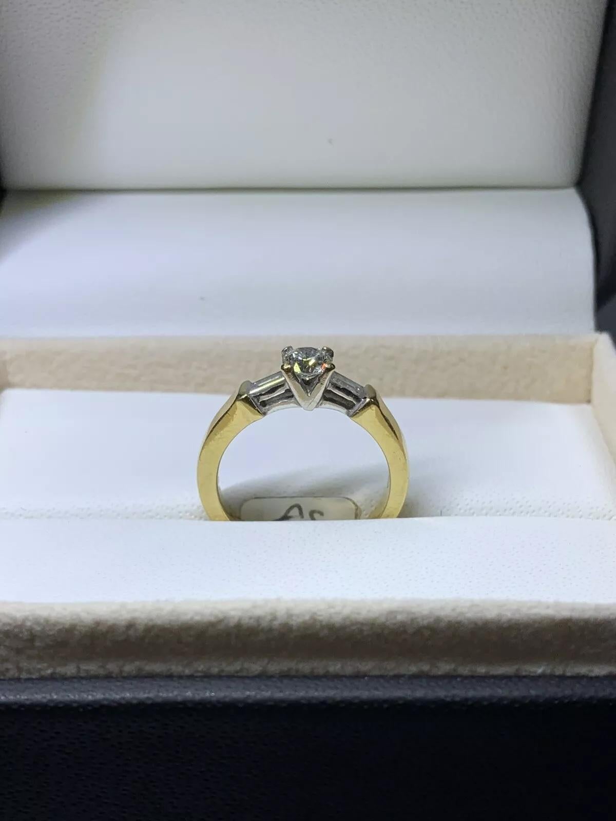 Round Cut 0.55ct Round and baguette diamond trilogy engagement ring in 18k yellow gold. For Sale