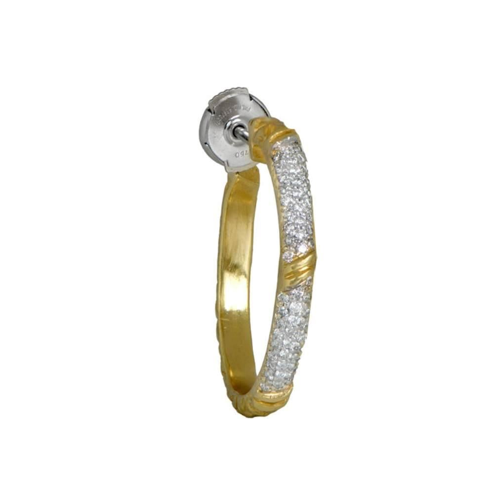 Indulge in the captivating allure of the Tifferet diamond and 18k yellow gold hoop earrings, reminiscent of the popular 70s jewelry style. 

These exquisite earrings showcase a harmonious blend of classic and contemporary aesthetics. Adorned with a
