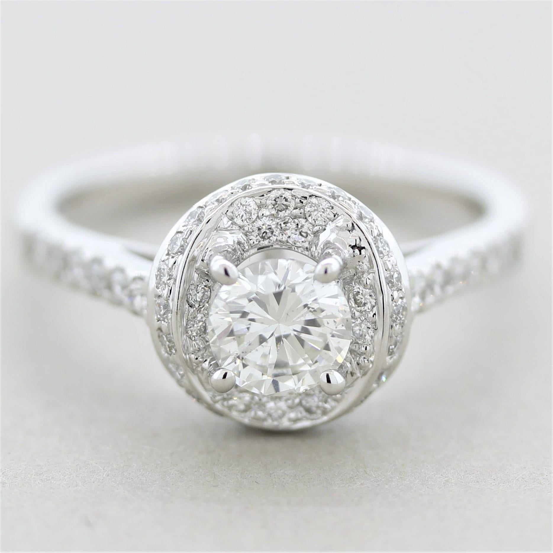 A simple yet elegant diamond engagement ring featuring a 0.58 carat round brilliant-cut diamond in the center. It is bright and lively with no eye-visible inclusions and great color. It is accented by an additional 0.37 carats of round diamonds