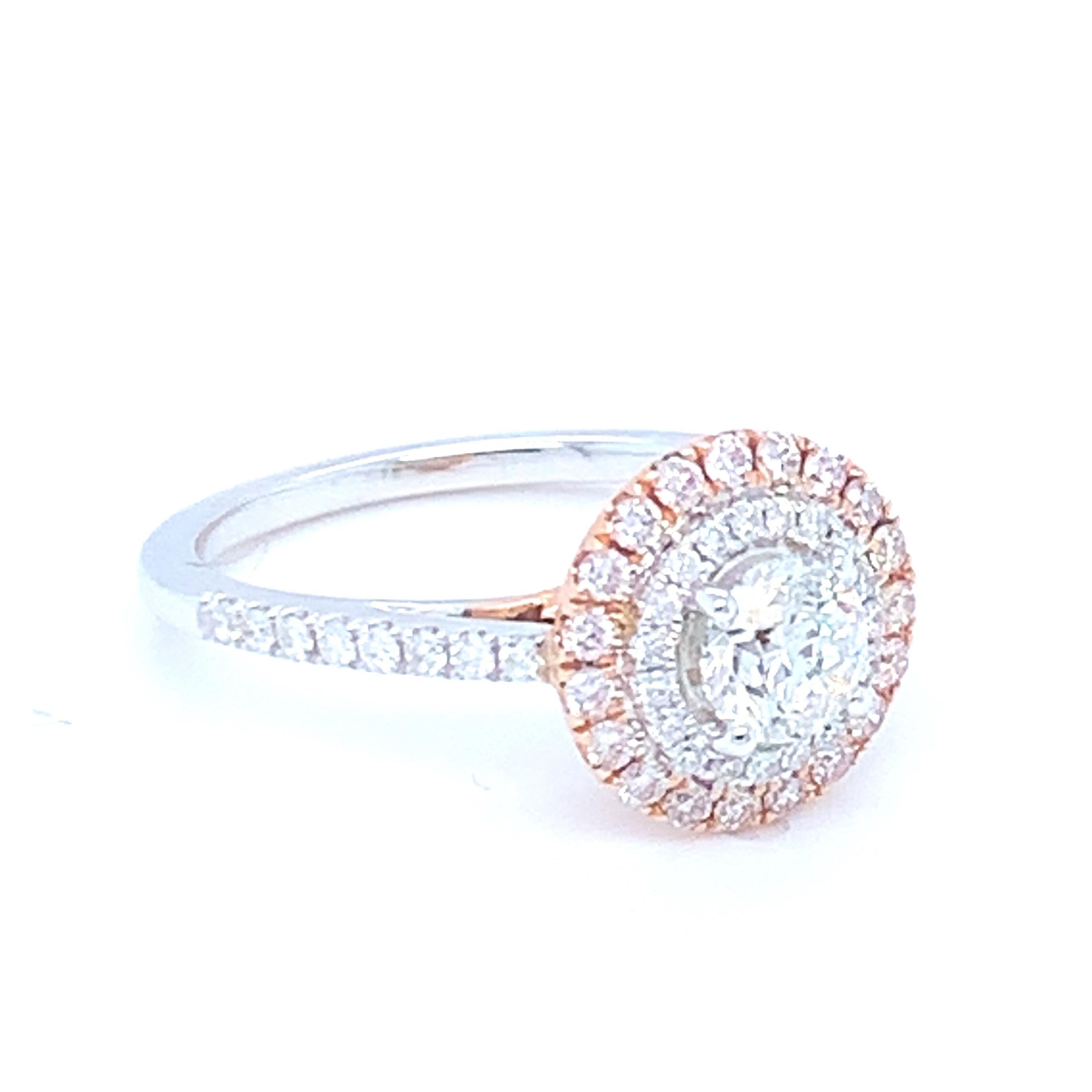 This lovely halo ring features a round diamond in the center surrounded by white and pink diamonds. Set in two tone gold to match the two tone diamond settings. This piece has been crafted by hand to achieve the finest quality. 
Center diamond:
