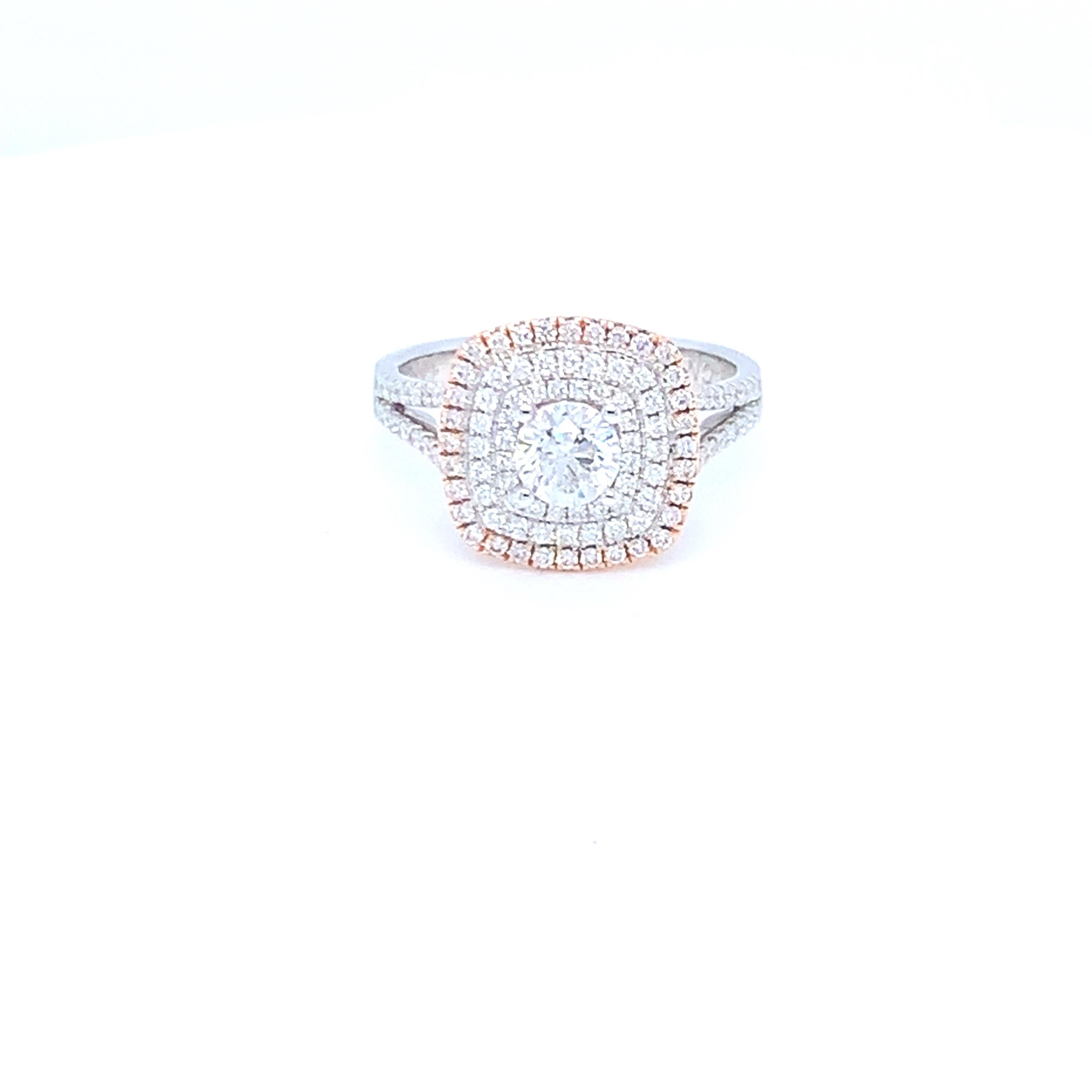 This lovely ring features a halo design in white and pink diamonds. Set in two tone gold to match the two tone diamond settings. This piece has been crafted by hand to achieve the finest quality. 
Center diamond: 0.58ct
Pink diamond: 0.14ct
White