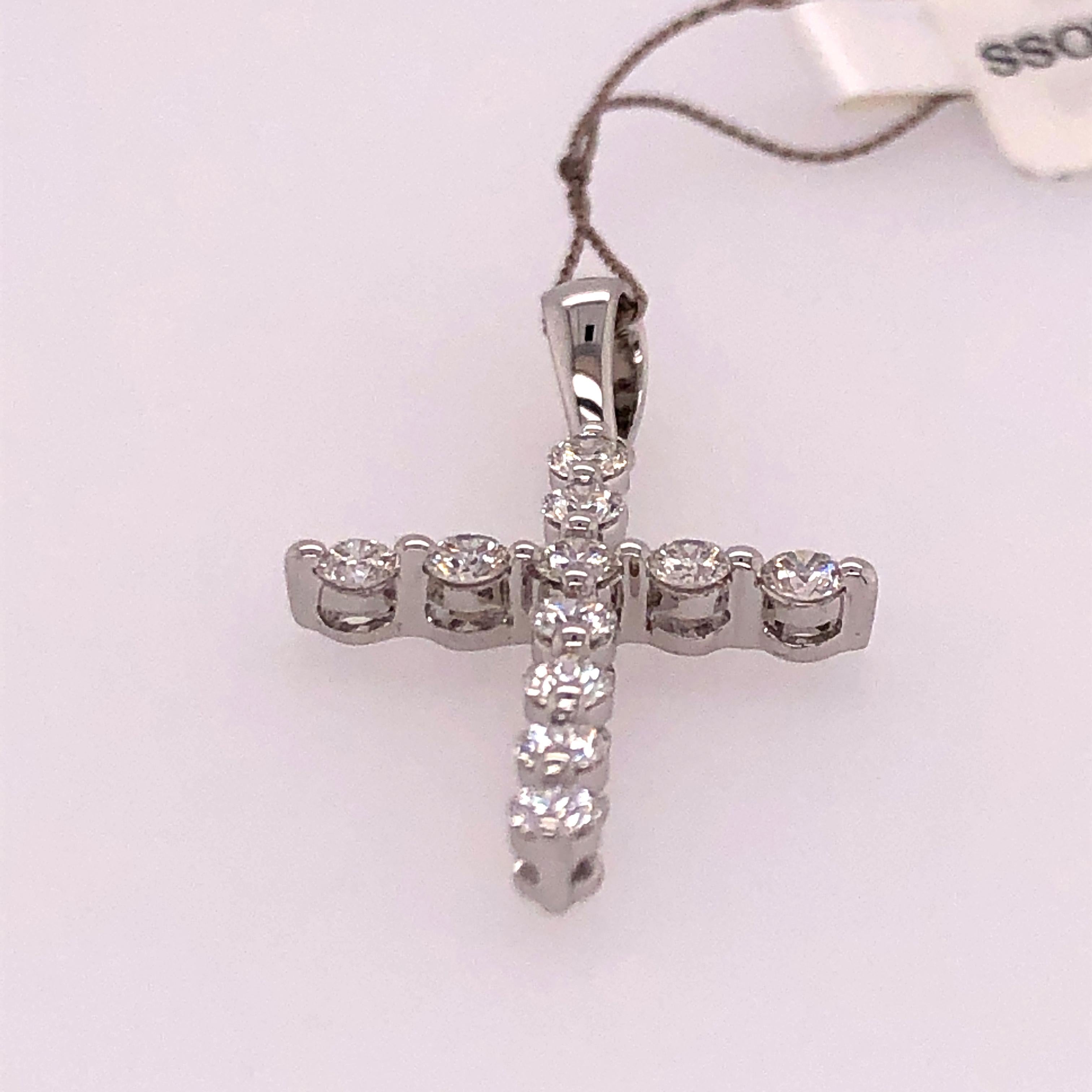 The simple design of this medium size diamond cross pendant is perfect for daily wear. It adds a touch of brilliance while keeping your faith close to your heart. 
11 round diamonds of a total carat weight of 0.58 CT are prong set into white gold