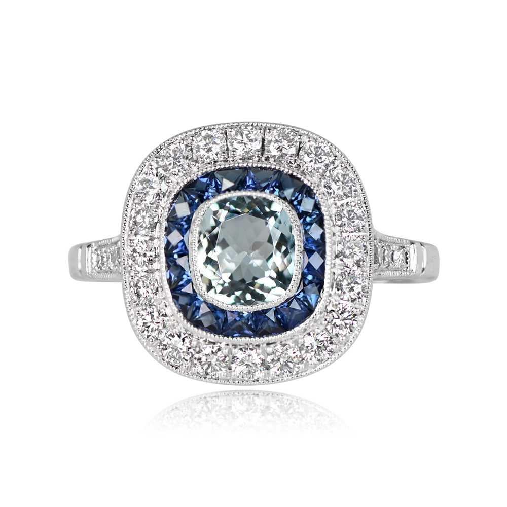 A stunning platinum ring featuring a 0.58-carat cushion-cut aquamarine at its center. This exquisite gemstone is encircled by two halos: one composed of calibrated natural French-cut sapphires, and the other of round brilliant-cut diamonds. The
