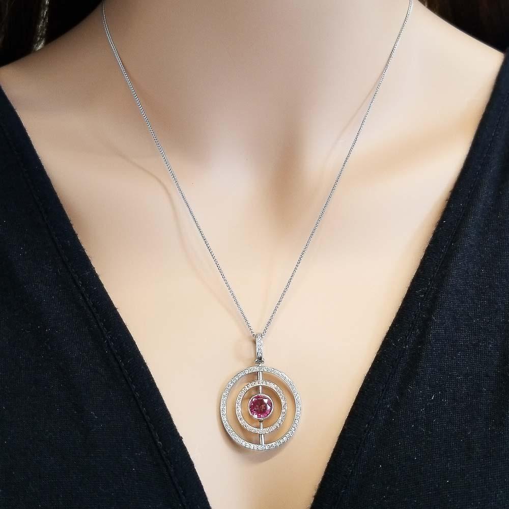 Extraordinary and versatile! That’s exactly what you'll say when you feast your eyes on this gorgeous contemporary pendant. The round pink rubellite is from Brazil. Two diamond frames featuring an the inner spinning halo to show natural pink