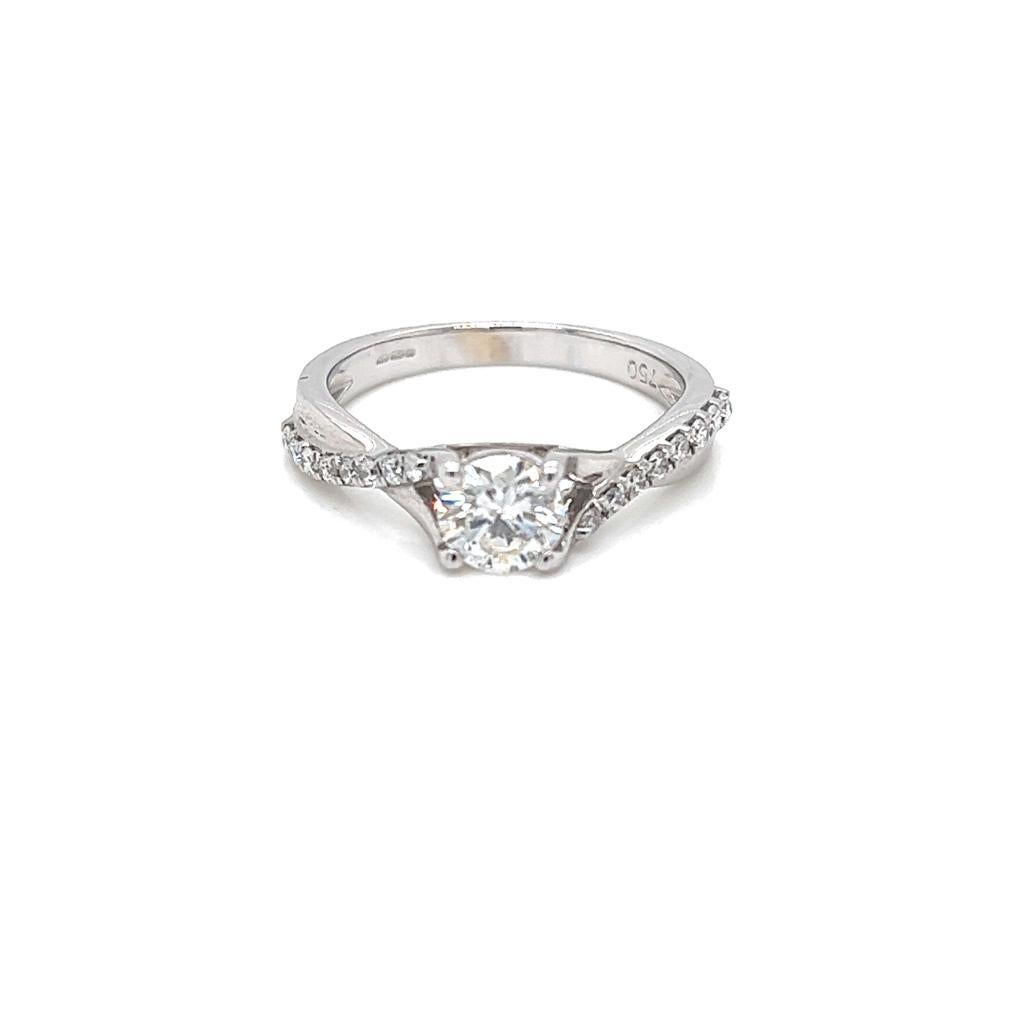 0.6 Carat Round Brilliant Diamond Ring in 18 Karat White Gold.

This elegant ring features a round brilliant Diamond at its centre, held in a claw setting on an 18K White Gold band. A curved diamond encrusted strand that joins the White Gold band to