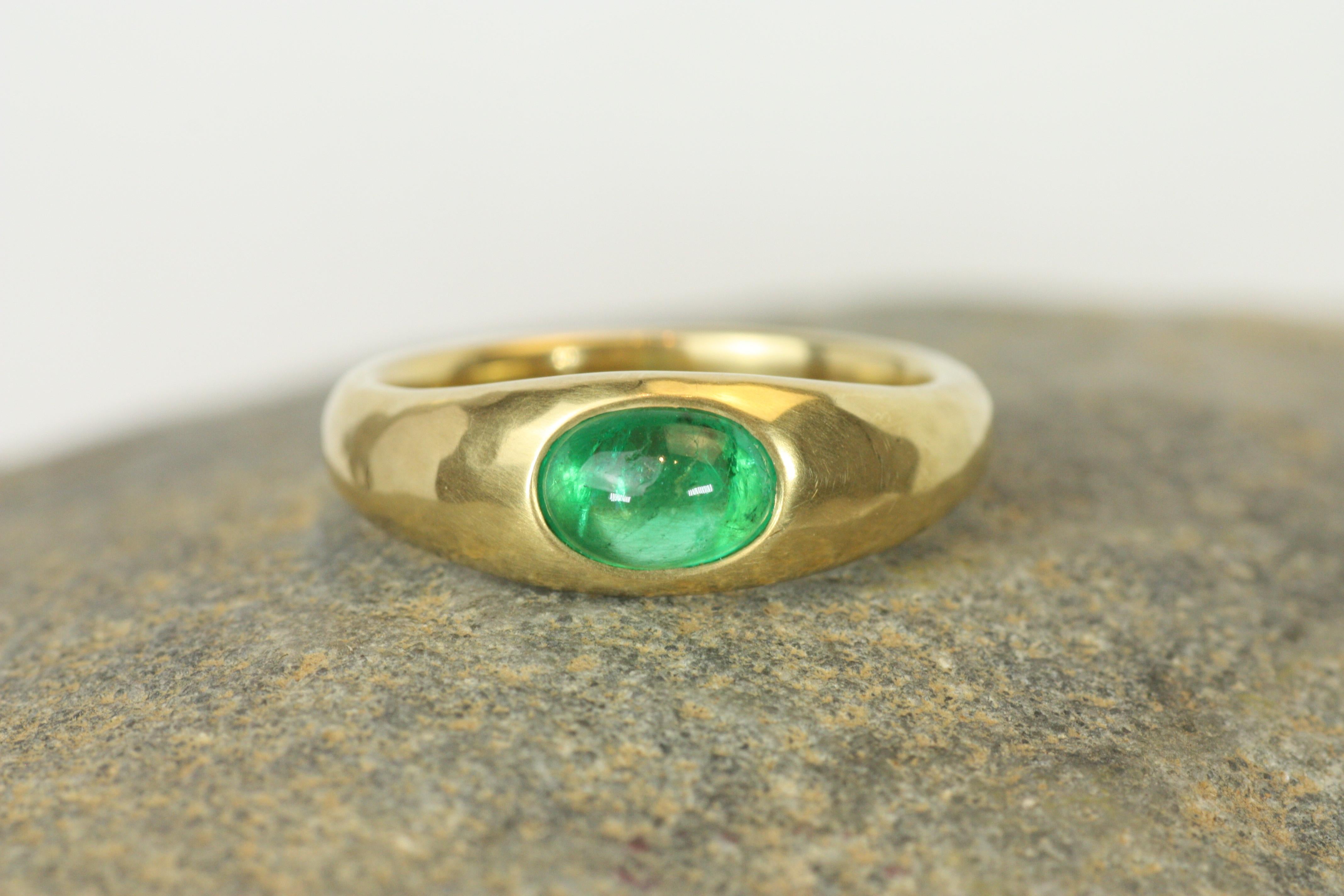 Experience the captivating beauty of a deep green emerald with this handcrafted gypsy ring. The 0.60ct cabochon emerald is set in rich 18K yellow gold that features a soft-hammered finish, creating a timeless and refined look. The smooth cabochon