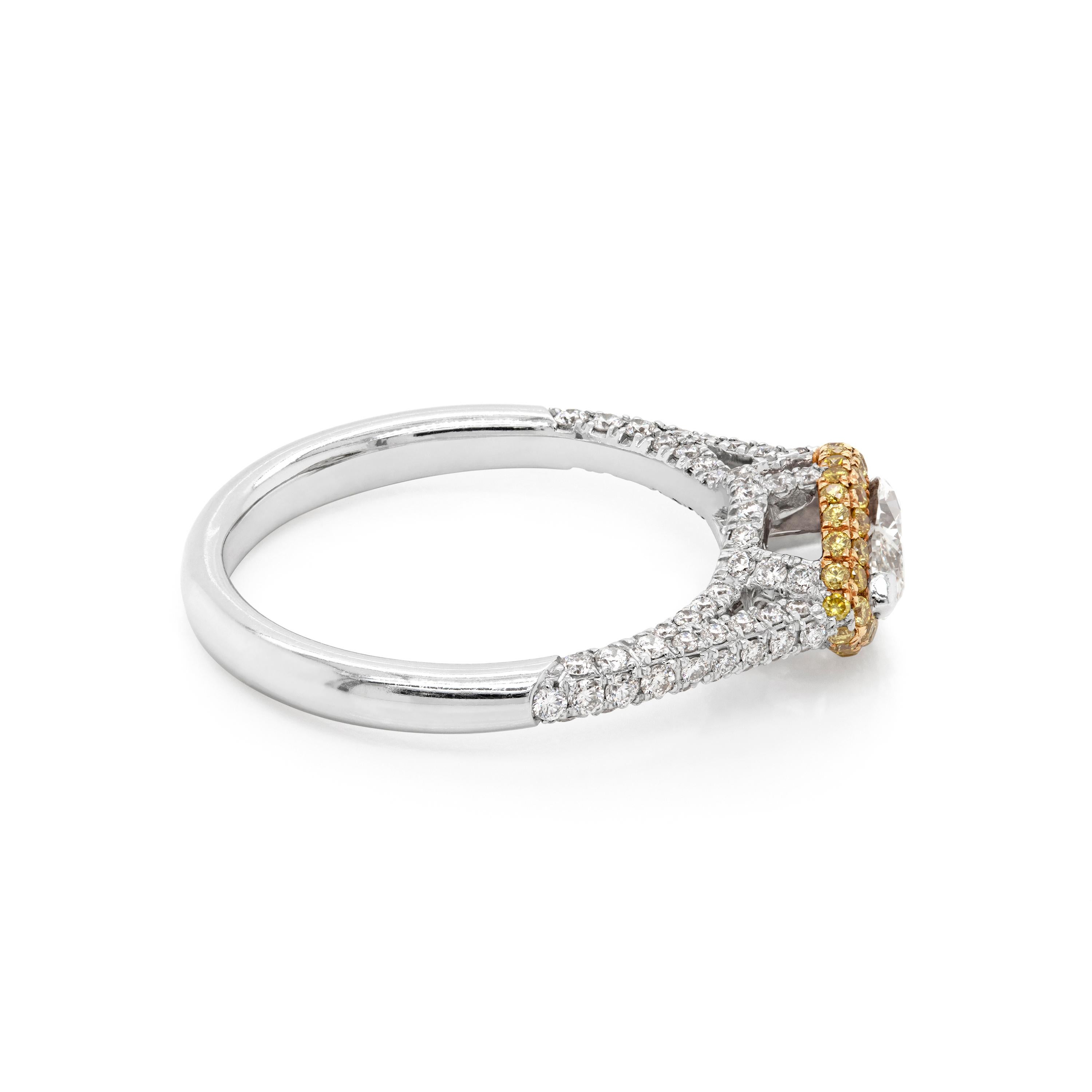 This stunning ring features a fine quality horizontally set marquise shape diamond weighing 0.60ct mounted in a 'V' claw, open back setting. The center stone is surrounded by a beautiful halo of 44 round fancy yellow diamonds totaling to