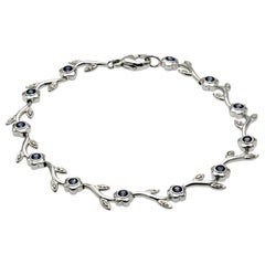 0.60 Carat Natural Blue Sapphire 
0.12 Carat Diamonds 14K Gold Flower Bracelet