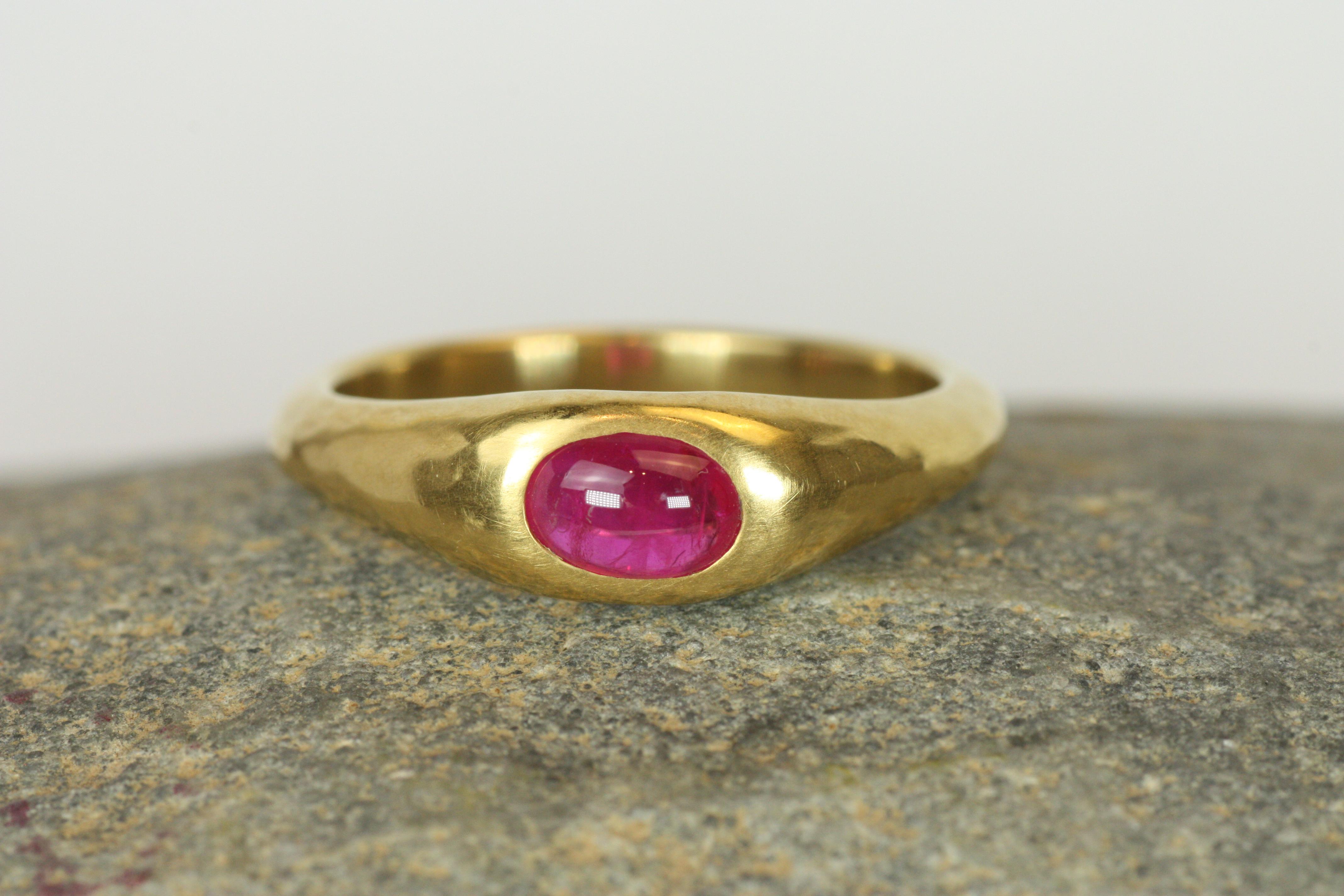 This handcrafted gypsy ring is a true standout, featuring a radiant 0.60ct oval cabochon ruby set in luxurious 22K yellow gold. Its matte hammered finish complements the vibrant ruby, making it a perfect piece for the discerning jewelry lover. The