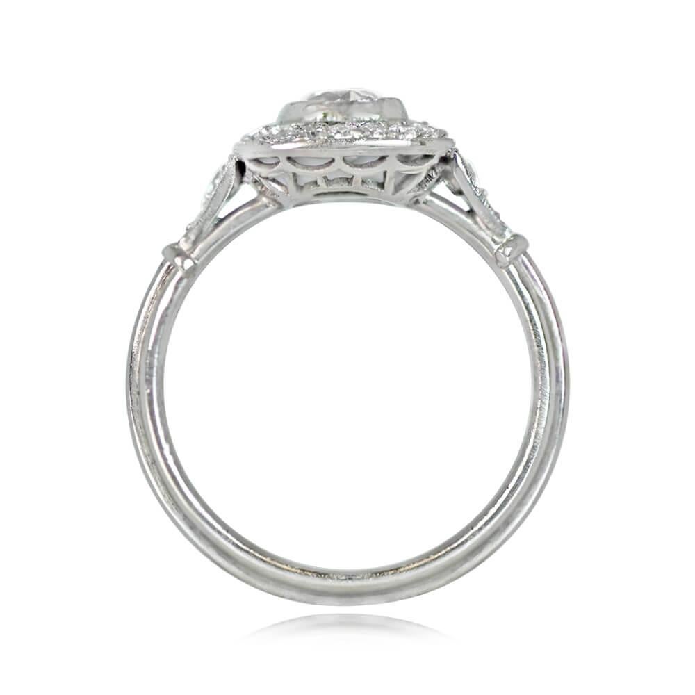 Featuring a delicate antique cushion-cut diamond, this ring is set in handcrafted platinum and surrounded by an antique diamond halo. The intricate under-gallery showcases openwork filigree and a triple wire shank, enhanced with diamond-studded leaf