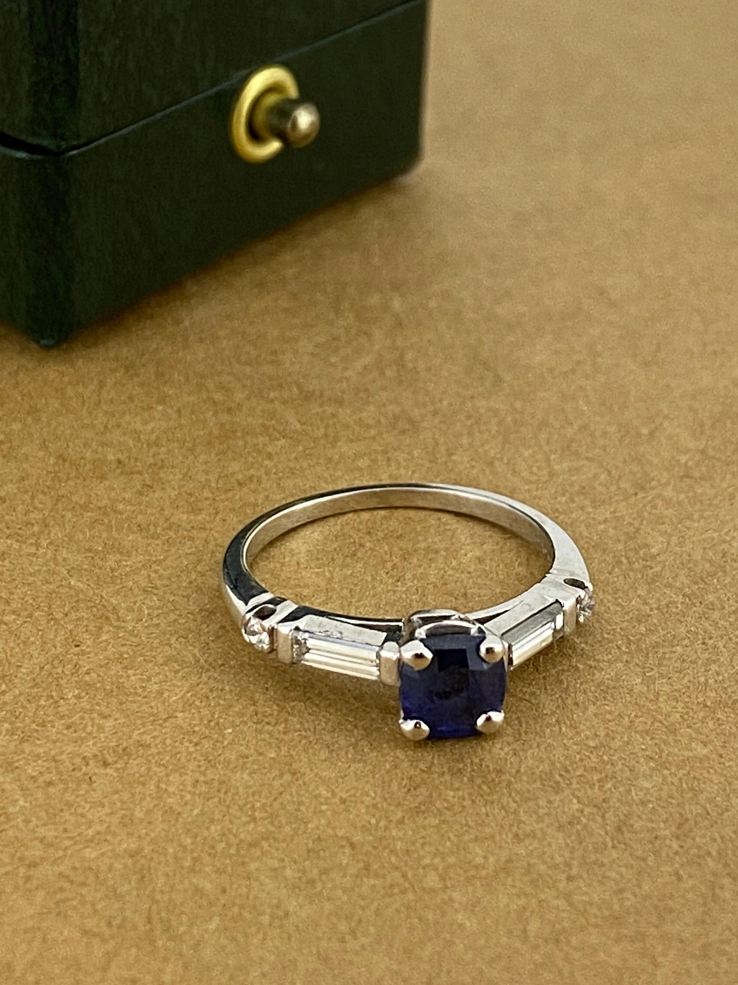 This elegant piece of jewelry is handmade, 
centrally set with a Ceylon (Sri Lankan) Sapphire
of desirable cushion shape,
of 0.60ct approx, 
of deep blue to midnight blue colour 

Flanked by 2 tapered baguette cut diamonds 
& further decorated by
