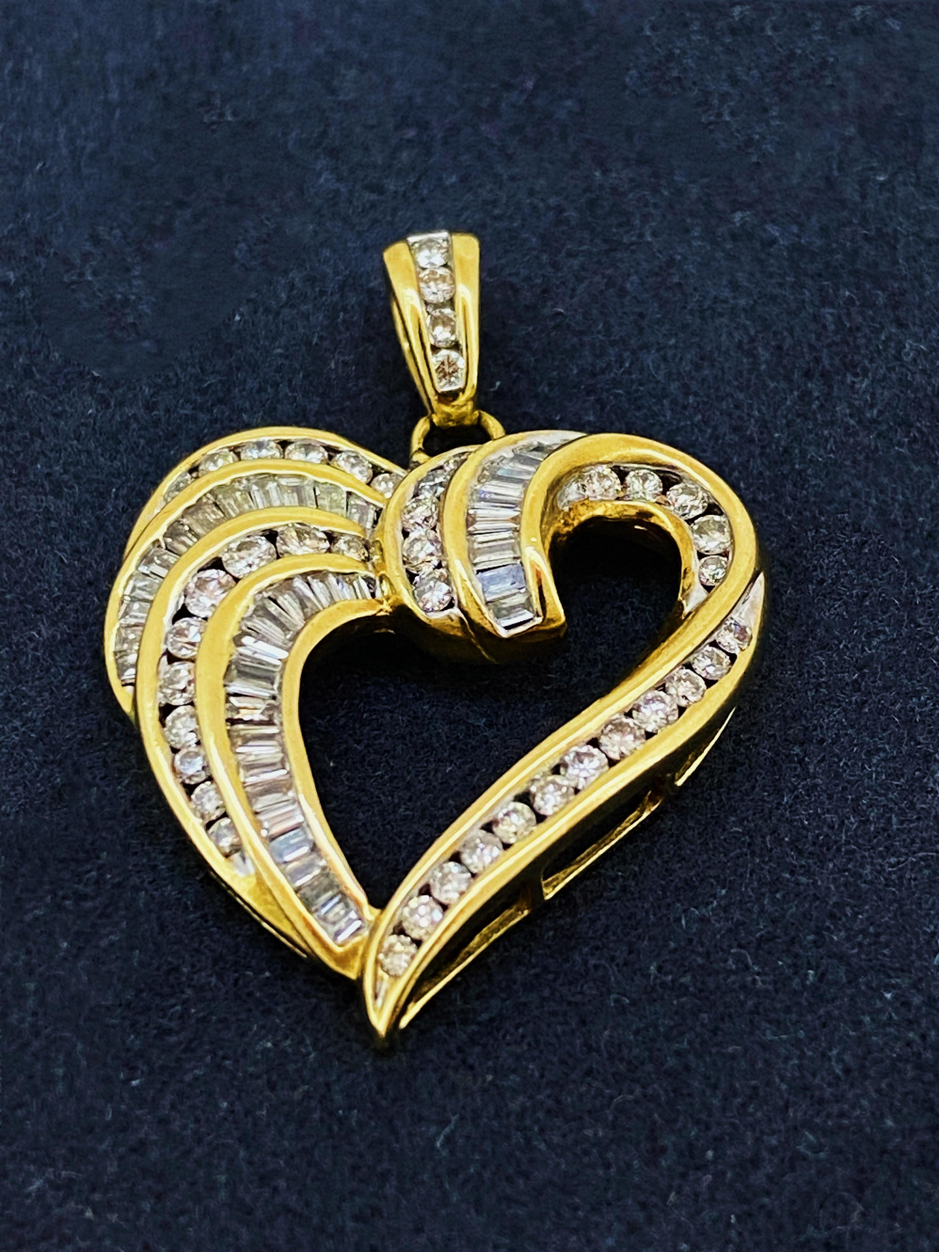 Of timeless design - in a shape of open heart -
the pendant is crafted in 9K Yellow Gold 
(stamped 375 on a bail)

Lavishly channel-set with sparkling 
Baguette & Round Brilliant Cut Diamonds
(in several rows)
Bail is also adorned with round