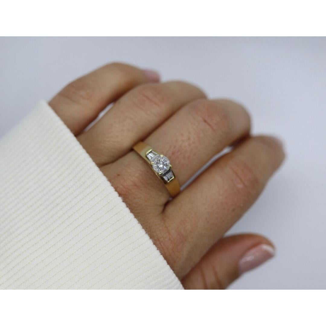 Vintage from the 1980s
Materials: Stone
Gemstone: Diamond
Gem Color: Colorless

Style: Mid-century

Beautiful Diamond Solitaire set into 14k Yellow Gold. Beautiful Round center stone with 4 tapered baguette diamond accents. Diamond is certified by