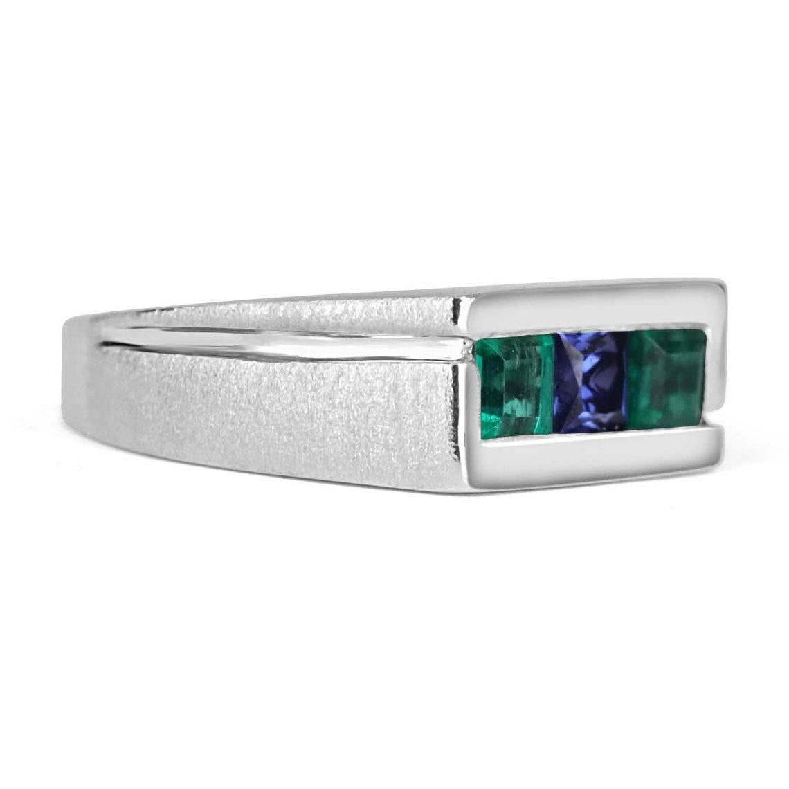This is a 0.60 carat unique Colombian emerald & Tanzanite mens band. Sleek in every sense of the word and simply comfortable make this band the ideal ring have. Two, high-quality Colombian emeralds are channel set into an 10K white gold frame with a
