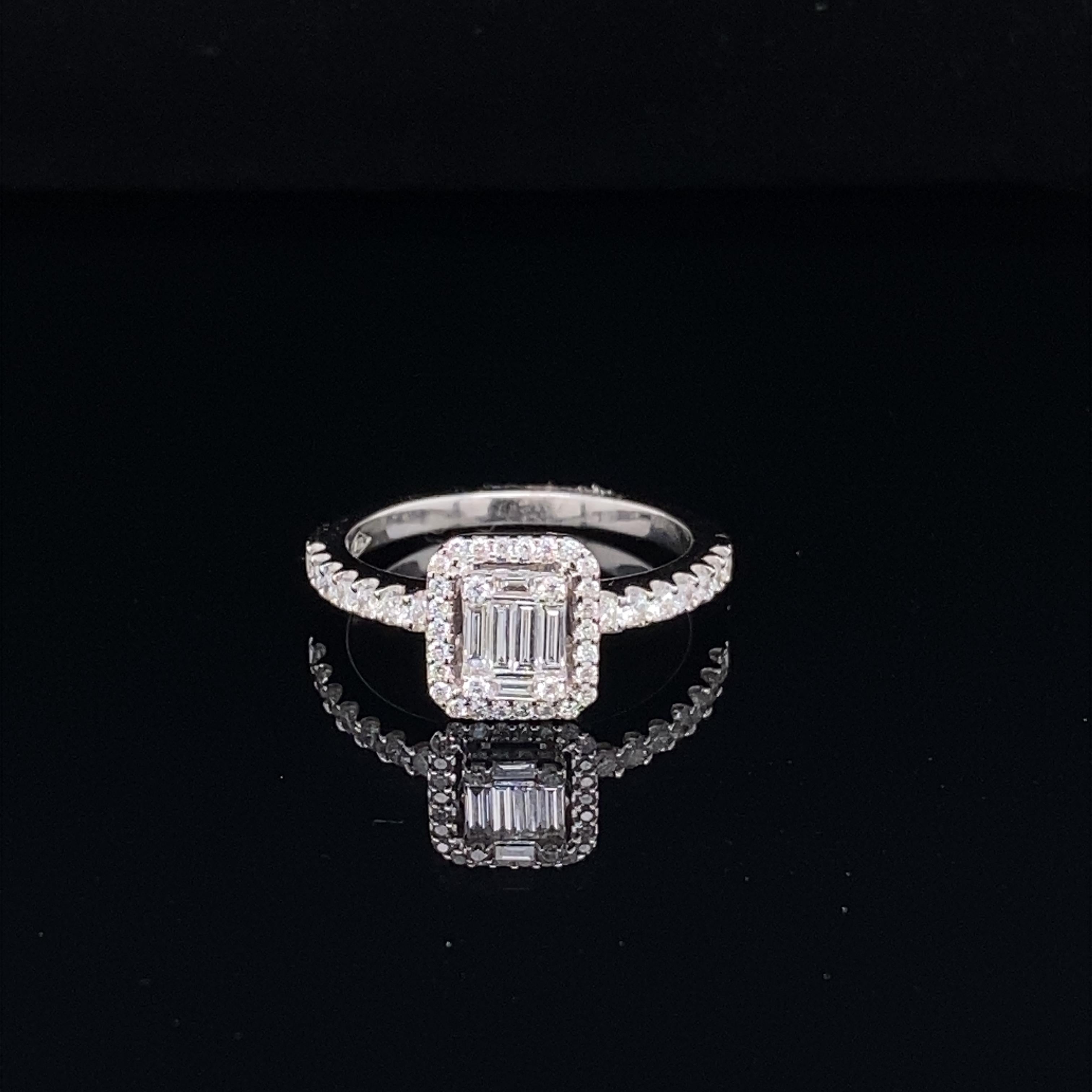 This stunning ring features a beautiful Emerald Cut Cluster of White Diamonds comprising of Baguette and Round Diamonds, surrounded by a Diamond Halo. The Diamond Cluster sits on a Diamond Shank. This ring is set in 18K White Gold.
Total Diamond
