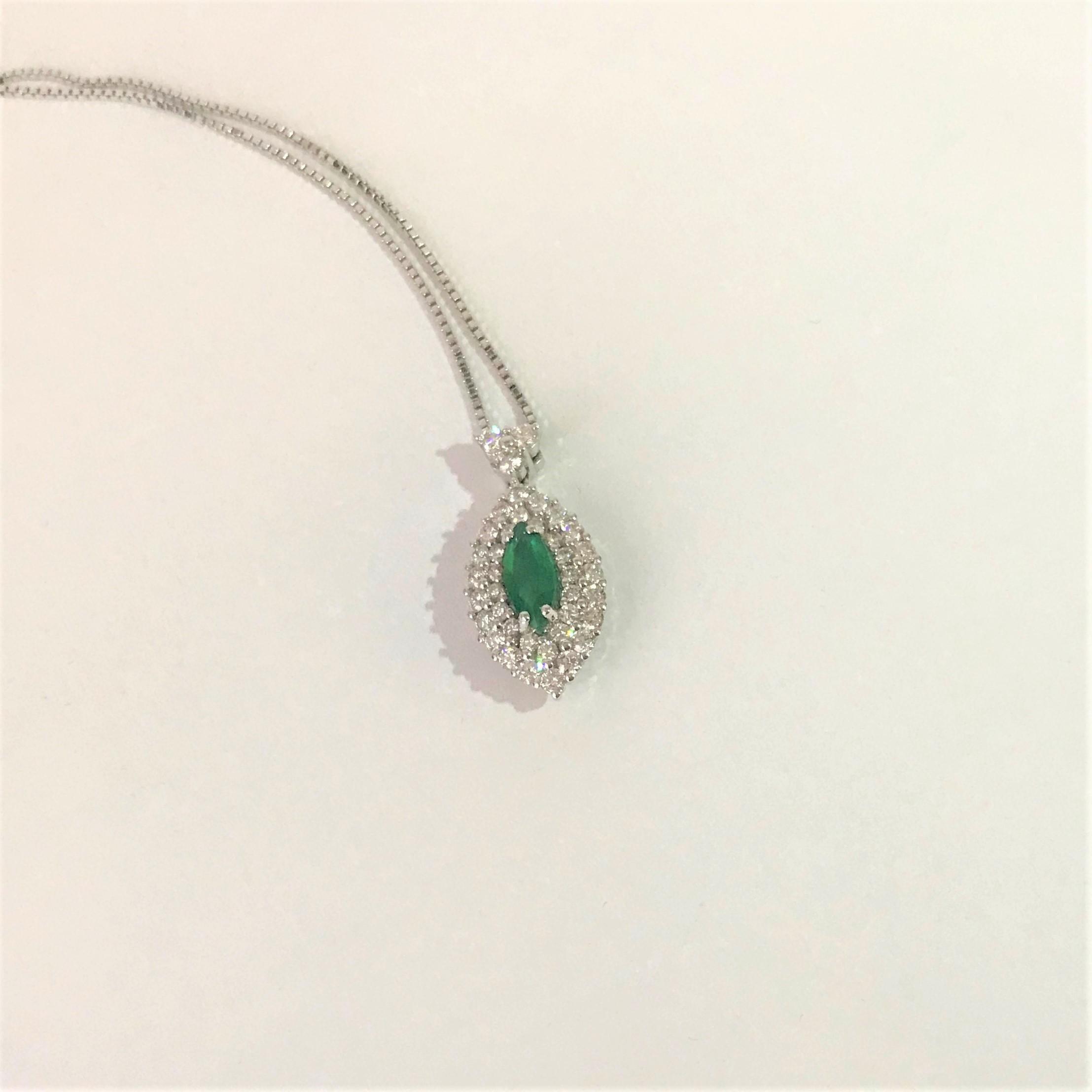 Oval shape pendant with a central  0.61 carat  Emerald, and  1.11 carat Round brilliant cut Diamonds.
The necklace is 18 k white gold.
Chain is 42 cm long. 
The high quality of this jewel is the expression of the skilful work of our goldsmiths
All