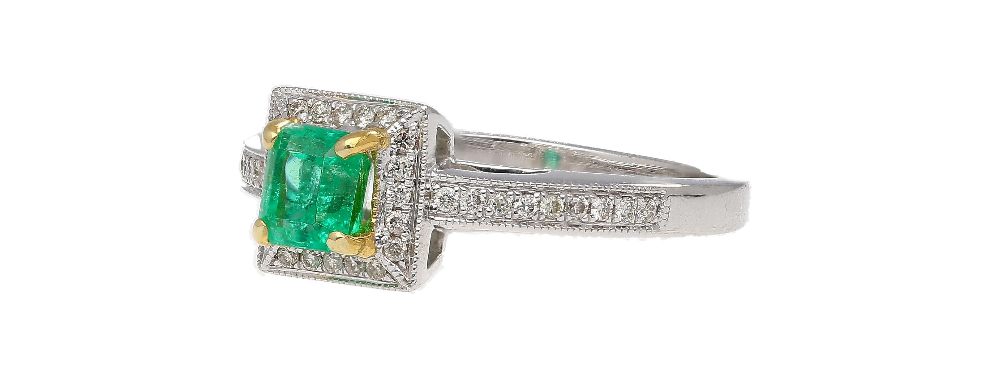 0.61 Carat Emerald and Diamond Ring in 14K White Gold. Beautiful vintage-style Emerald ring with round-cut diamonds surrounding the deep green center stone in a halo shape and all along the traditional style ring shank. The center stone is prong-set