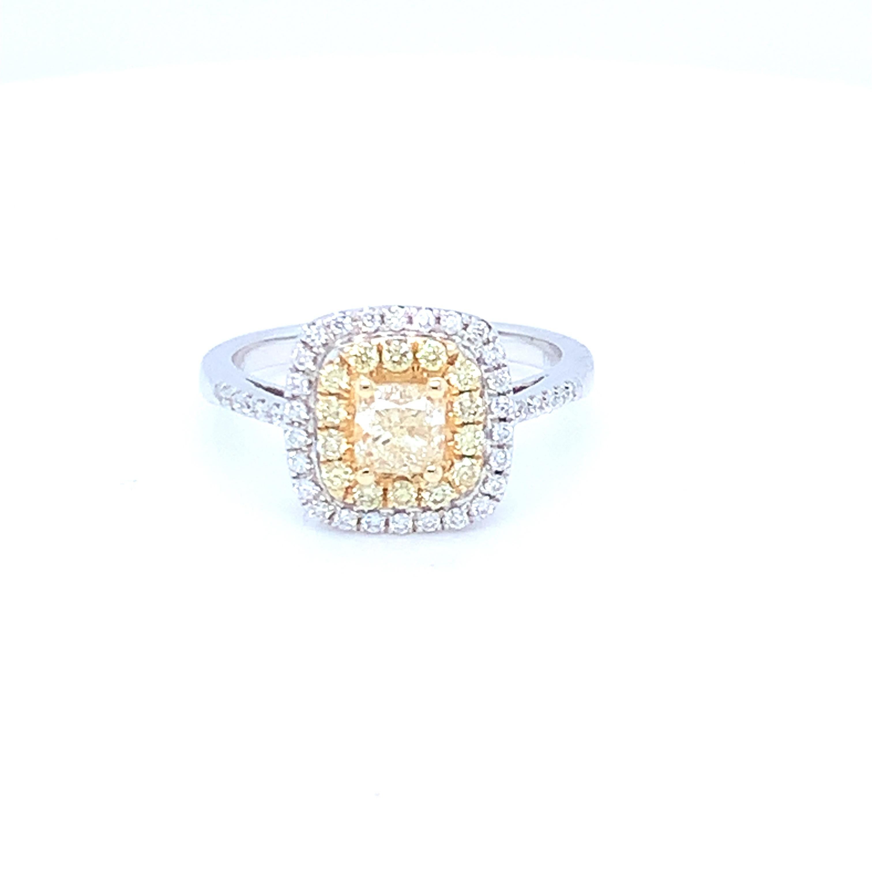 This lovely ring features a halo design in yellow and white diamonds. Set in two tone gold to match the two tone diamond settings. This piece has been crafted by hand to achieve the finest quality. 
Center yellow diamond: 0.62ct
Yellow diamond: