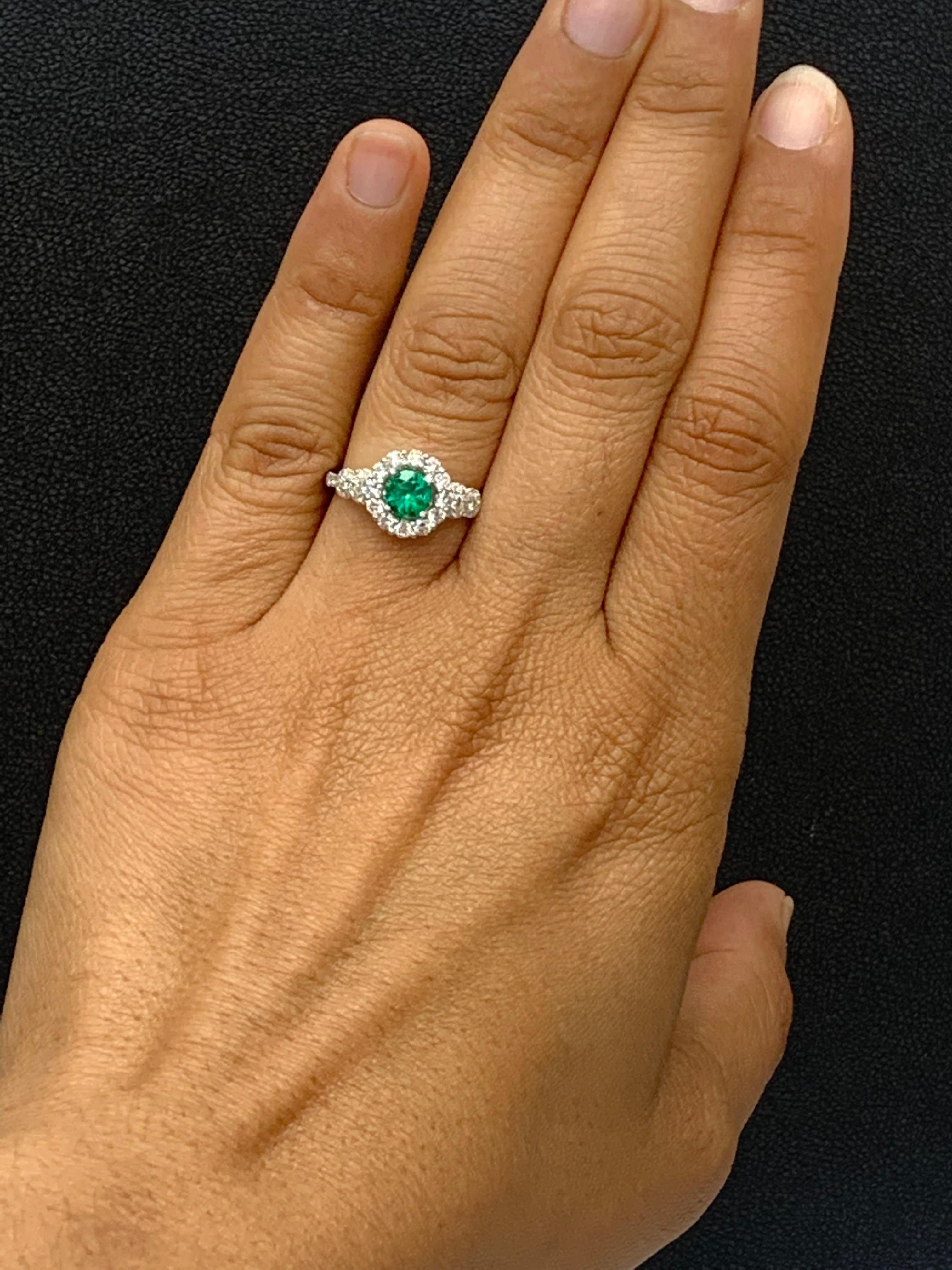 Features a gorgeous flower design  0.62 carat round cut lush green emerald ring surrounded by a row of brilliant-cut 12 diamonds weighing 0.62 carats in total. Made in 18k white gold.