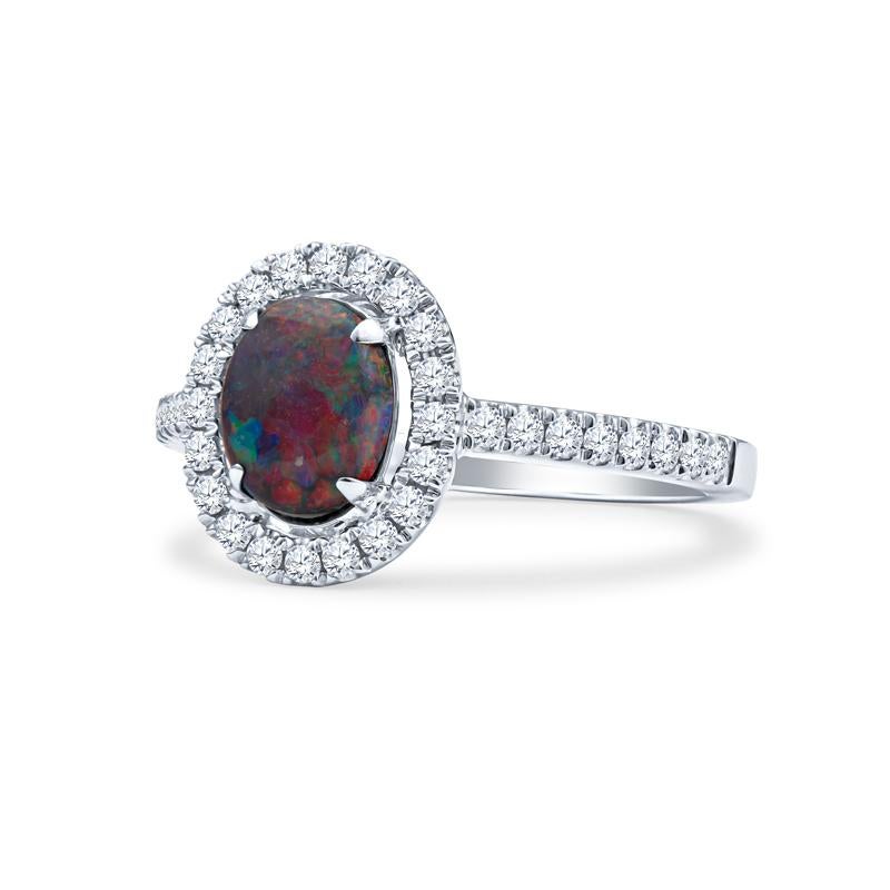 This ring features a 0.62ct multicolor Lightning Ridge Australian opal surrounded by 0.25ctw in diamonds forming a halo and going halfway down the shank. The ring itself is made of 18kt white gold. It is currently a size 6 but can be resized upon