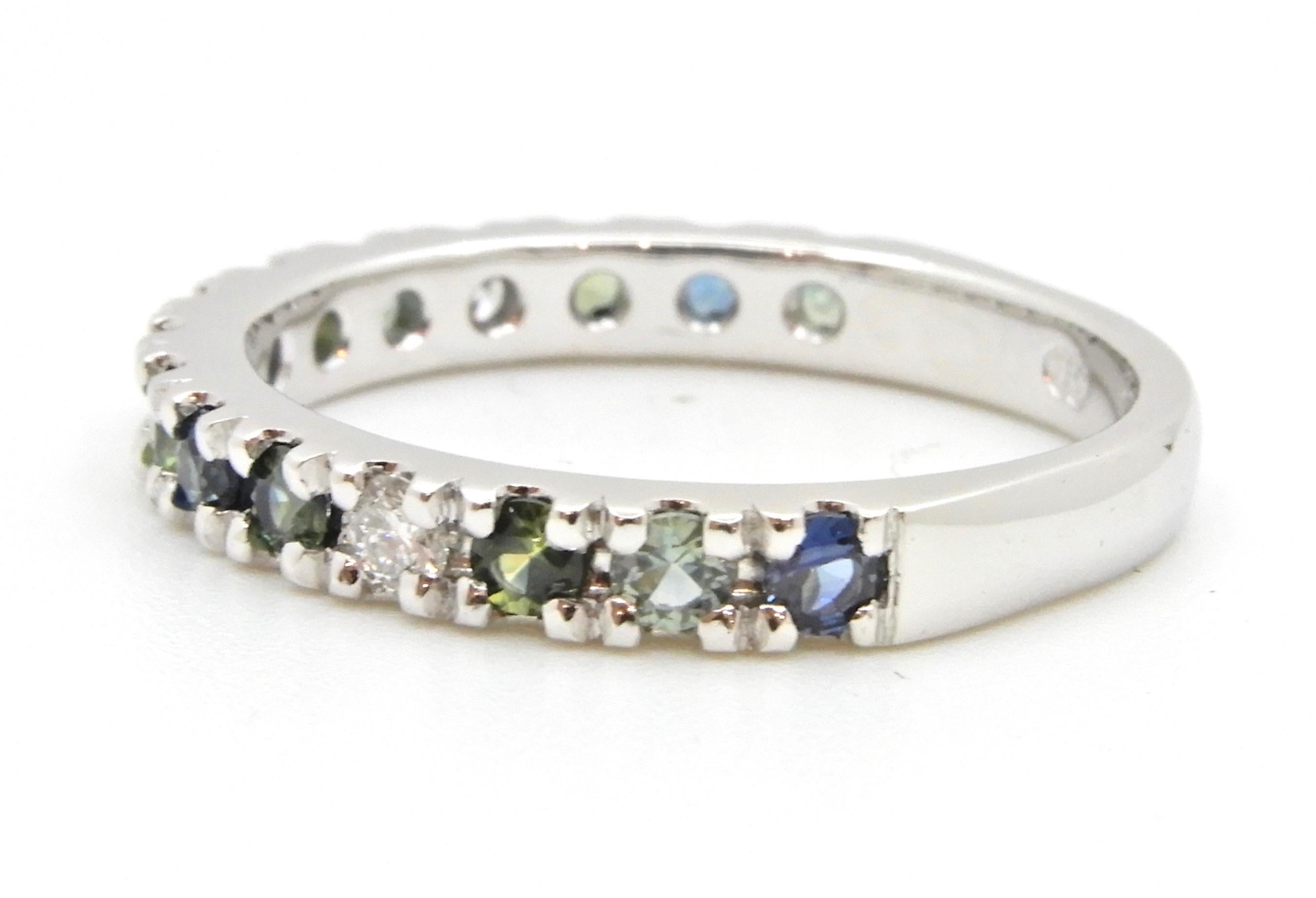 This 0.63 Carat Parti Sapphire and Diamond Wedding Ring is made in the half eternity band style. Set with 3 x 2.25mm (TDW = 0.14 Carat) of G colour SI clarity diamonds and 12 x 2.75mm round brilliant cut parti sapphires in blues and greens.

The