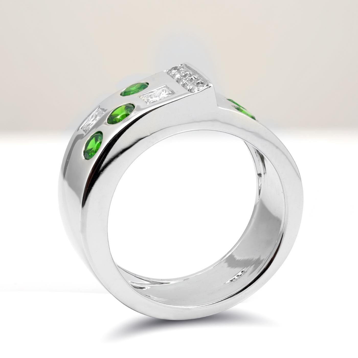 Filled with color of a lush forest these Russian Demantoid Garnets are truly ethereal. Set with accentuating diamonds that have been matched to perfection, this contemporary band makes a bold statement. The cool toned 14K white gold metal is what