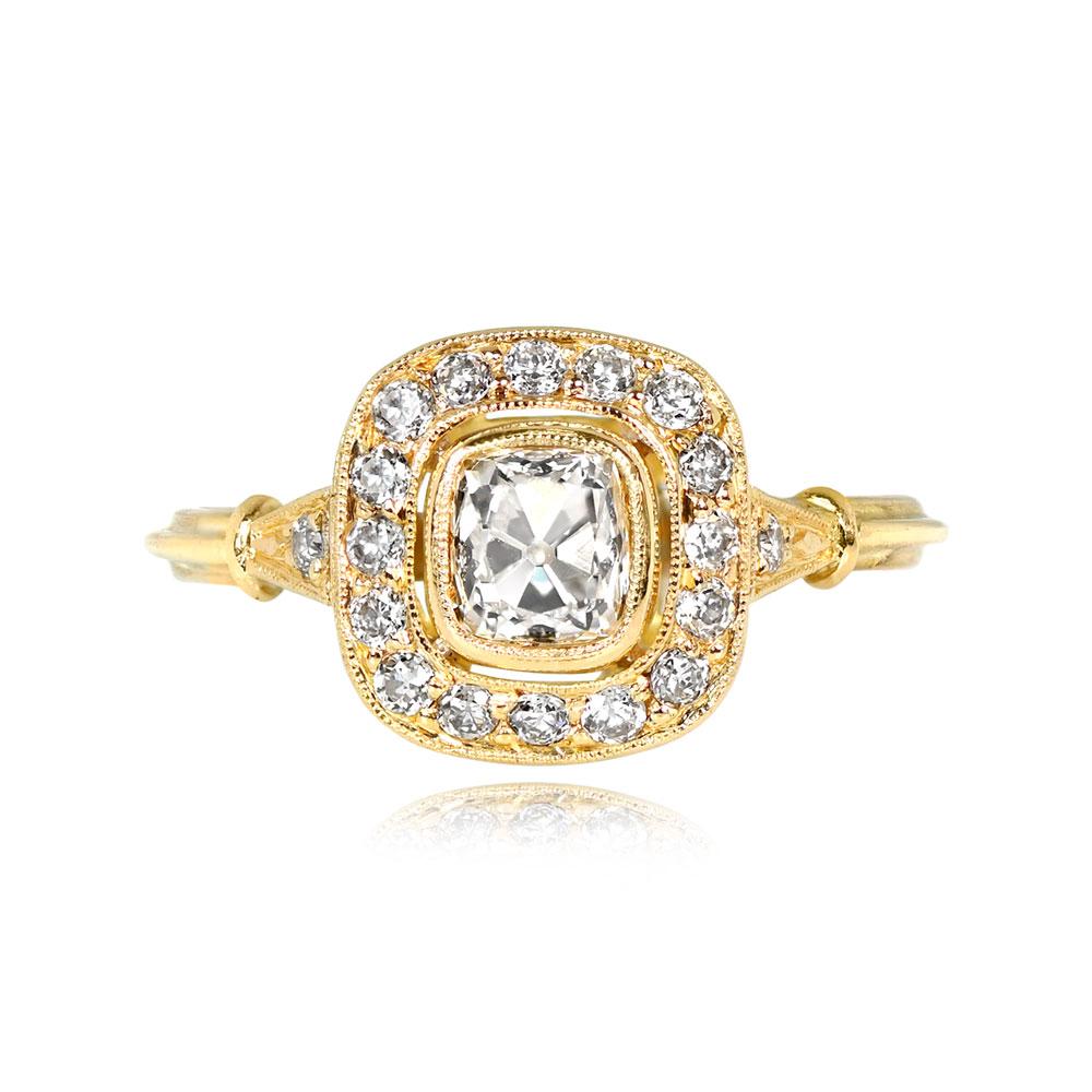 A captivating halo engagement ring showcasing an antique cushion-cut diamond weighing 0.63 carats. The center diamond boasts H color and VS1 clarity and is nestled within a halo of pave-set old European cut diamonds. The shoulders of the ring