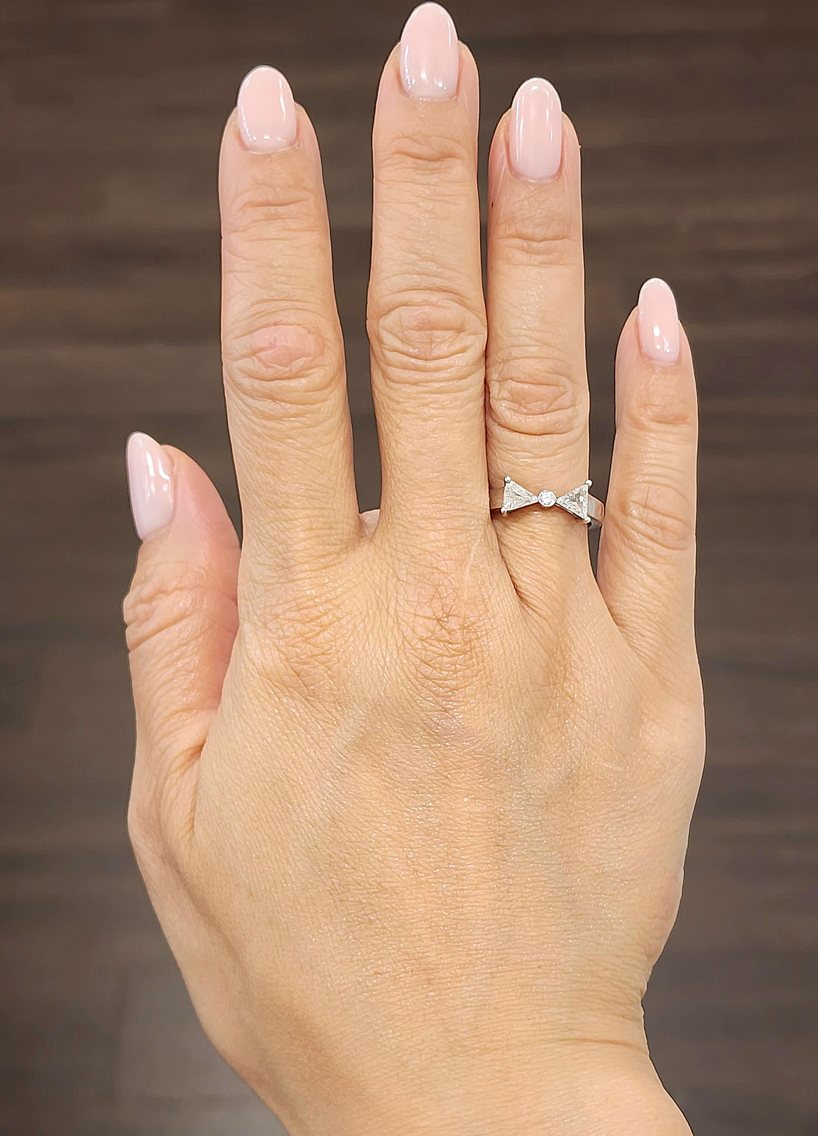 This modern 14k white gold ring showcases a striking bow tie design with a mixed cut diamond centerpiece. The diamond, weighing 0.64 carats, is white in color and graded G/H with a clarity of SI1/SI2. Crafted in 2023 in the United States, this